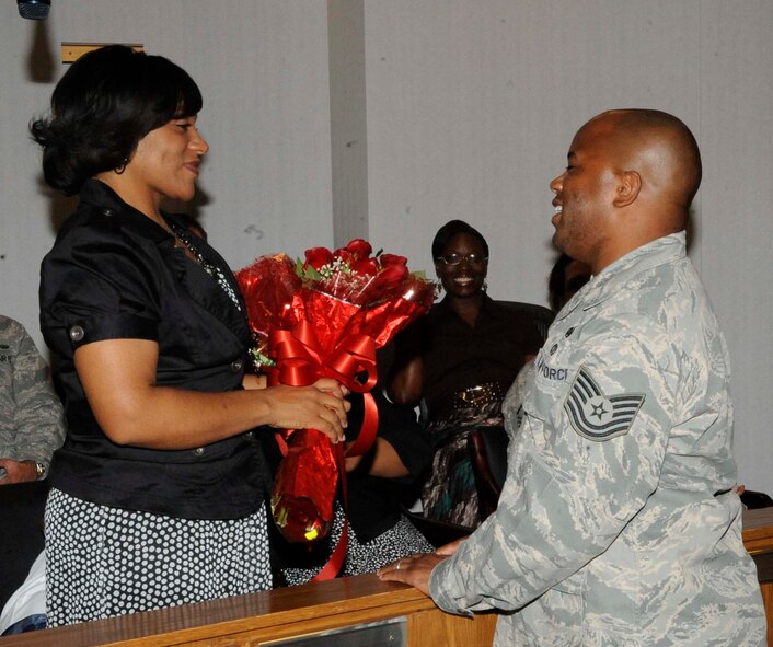 Staff Sgt. Geoffery Gunn, 2nd Bomb Wing Legal Office, gives his wife Felicia flowers during his technical sergeant promotion ceremony on Barksdale Air Force Base, La., Aug. 31. Gunn's wife, daughter and parent's attended the ceremony, while his younger sister viewed the ceremony via video teleconference from her deployed location in Southwest Asia. (U.S. Air Force photo/Staff Sgt. Terri Barriere) (RELEASED)