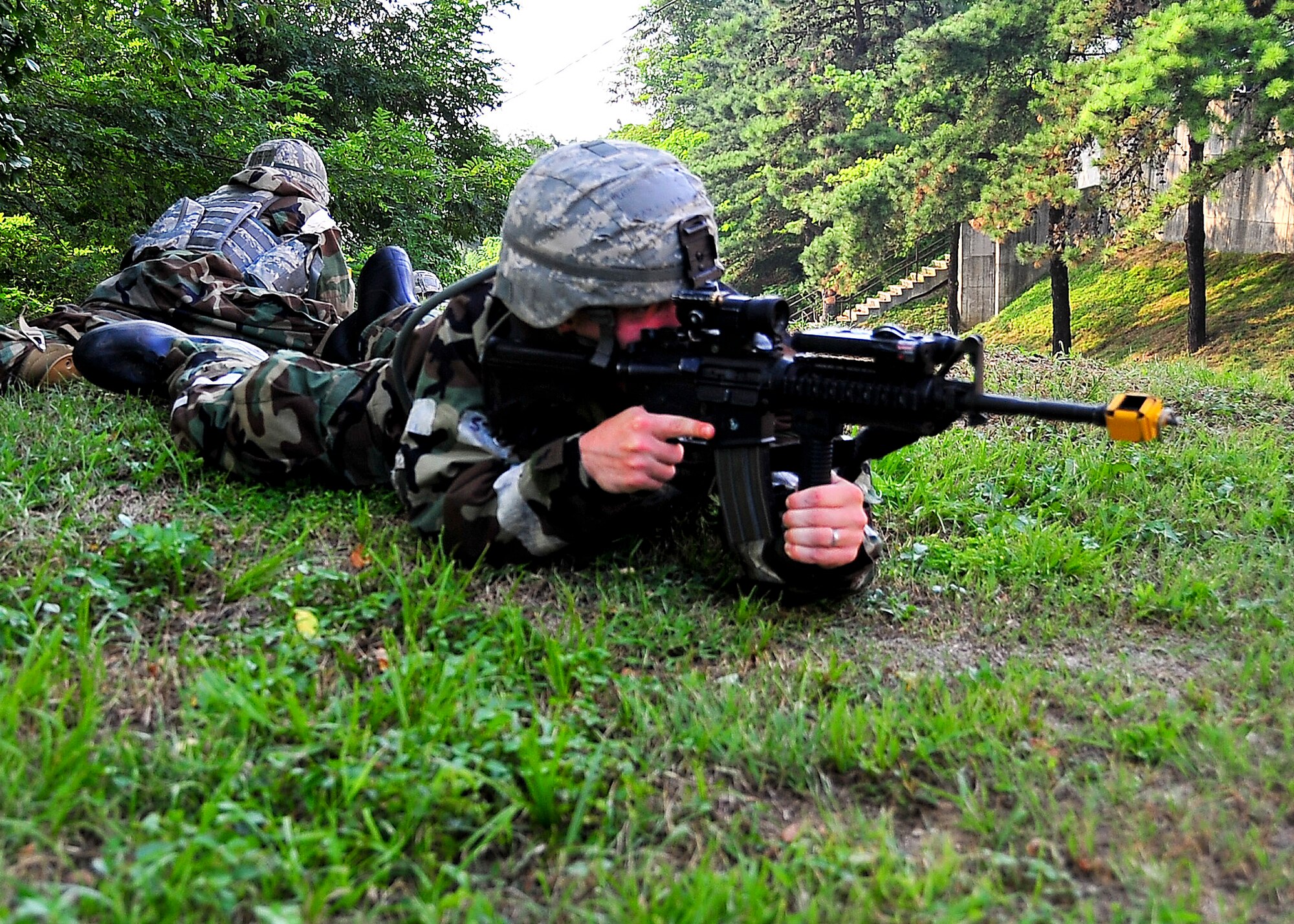 Airmen from the 51st Security Forces Squadron, take cover while covering different sectors of fire during a small arms attack on hill 180 Sep. 01, 2011 during exercise Beverly-Midnight 11-04. Exercises such as this test Osan's ability to survive and operate during a war-time constraint. (U.S. Air Force photo/Senior Airman Adam Grant)    