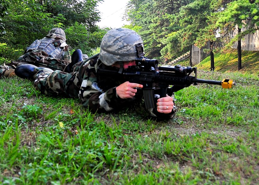 Airmen from the 51st Security Forces Squadron, take cover while covering different sectors of fire during a small arms attack on hill 180 Sep. 01, 2011 during exercise Beverly-Midnight 11-04. Exercises such as this test Osan's ability to survive and operate during a war-time constraint. (U.S. Air Force photo/Senior Airman Adam Grant)    