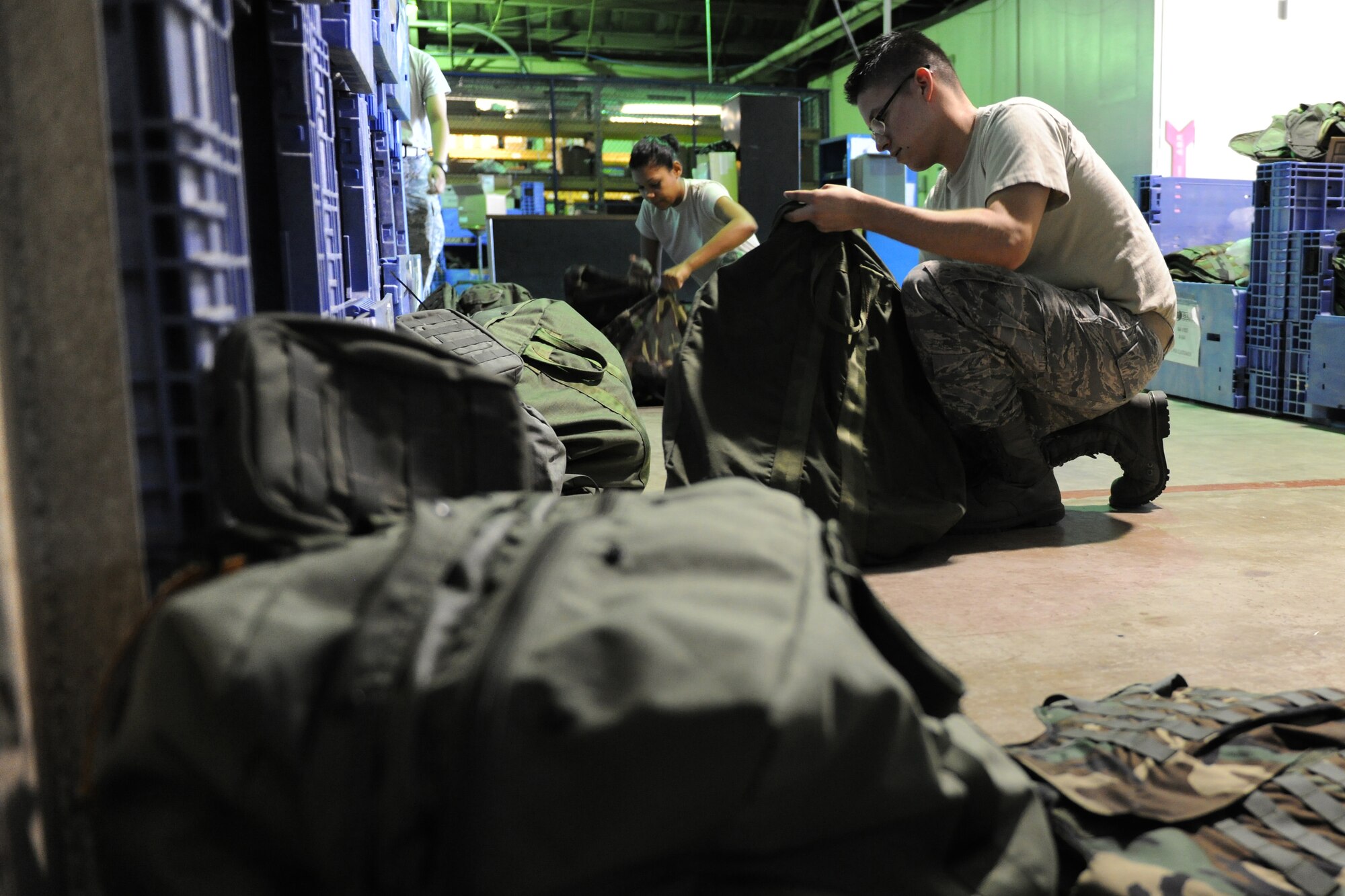 KUNSAN AIR BASE, Republic of Korea -- Senior Airman Alyse Bell and Airman 1st Class John Stringer, 8th Logistics Readiness Squadron individual protection equipment clerks, build training chemical gear bags for newcomers arriving on the Patriot Express here Sept. 1.  From in-processing and out-processing to taking inventory, these Airmen guarantee the Wolf Pack is able to survive a mortar or chemical attack. (U.S. Air Force photo/Senior Airman Brittany Y. Bateman)
