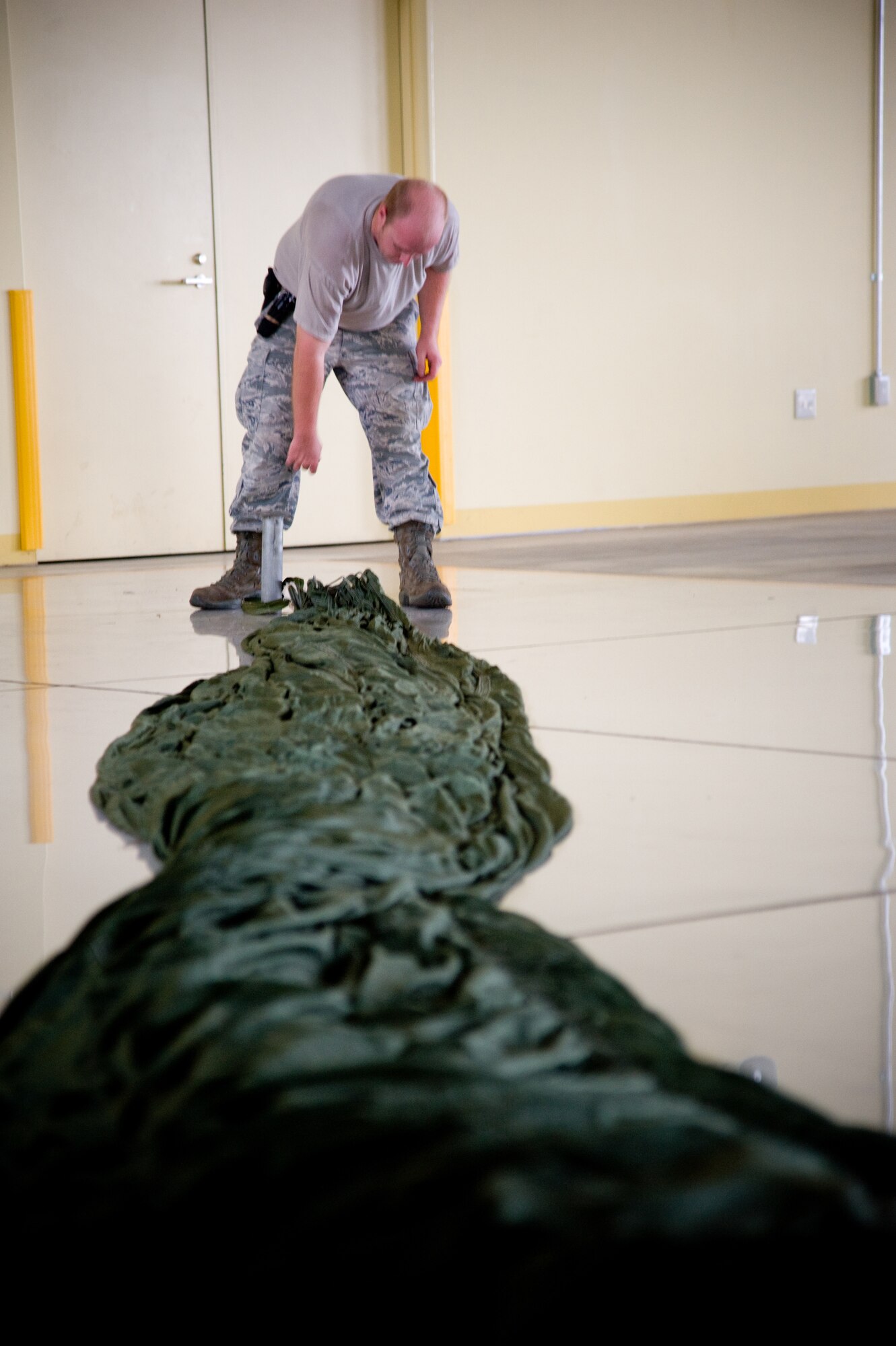 YOKOTA AIR BASE, Japan-- Senior Airman Brandon Wilson, 374th Logistics Readiness Squadron combat mobility flight rigger, prepares a G-12 E parachute for field packing at Yokota Air Base, Japan, Sept. 1, 2011. G-12 E parachutes are used for heavy load airdrops.(U.S. Air Force photo/Airman 1st Class Krystal M. Garrett)  