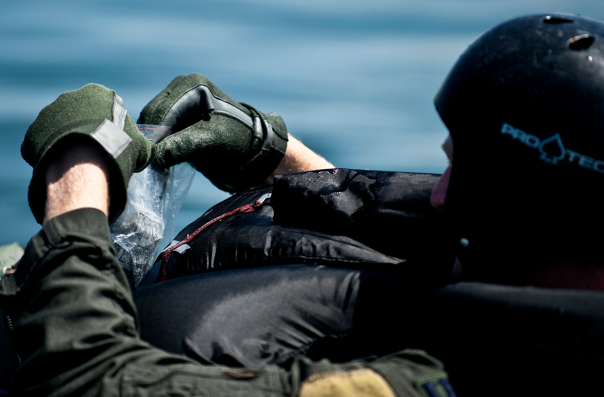 U.S. Air Force Capt. Justin Elliot, 422nd Test and Evaluation Squadron, F-15E Strike Division pilot, Nellis Air Force Base, Nev., puts items into his survival kit while floating in a raft on the lake during the Survival, Evasion, Resistance and Escape water survival training course Aug. 17, 2011, at Lake Mead, Nev. The training familiarizes Elliot with how to use each item he will have available after an ejection in order to stay alive and request a rescue. SERE specialists train high risk aircrew and personnel to survive, evade, and return safely should they eject, bailout, or otherwise become isolated during combat, anywhere in the world. (U.S. Air Force photo by Airman 1st Class George Goslin/Released)
