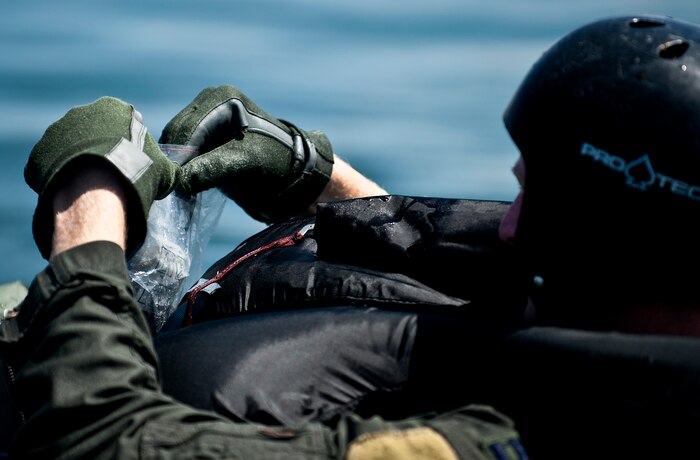 U.S. Air Force Capt. Justin Elliot, 422nd Test and Evaluation Squadron, F-15E Strike Division pilot, Nellis Air Force Base, Nev., puts items into his survival kit while floating in a raft on the lake during the Survival, Evasion, Resistance and Escape water survival training course Aug. 17, 2011, at Lake Mead, Nev. The training familiarizes Elliot with how to use each item he will have available after an ejection in order to stay alive and request a rescue. SERE specialists train high risk aircrew and personnel to survive, evade, and return safely should they eject, bailout, or otherwise become isolated during combat, anywhere in the world. (U.S. Air Force photo by Airman 1st Class George Goslin/Released)
