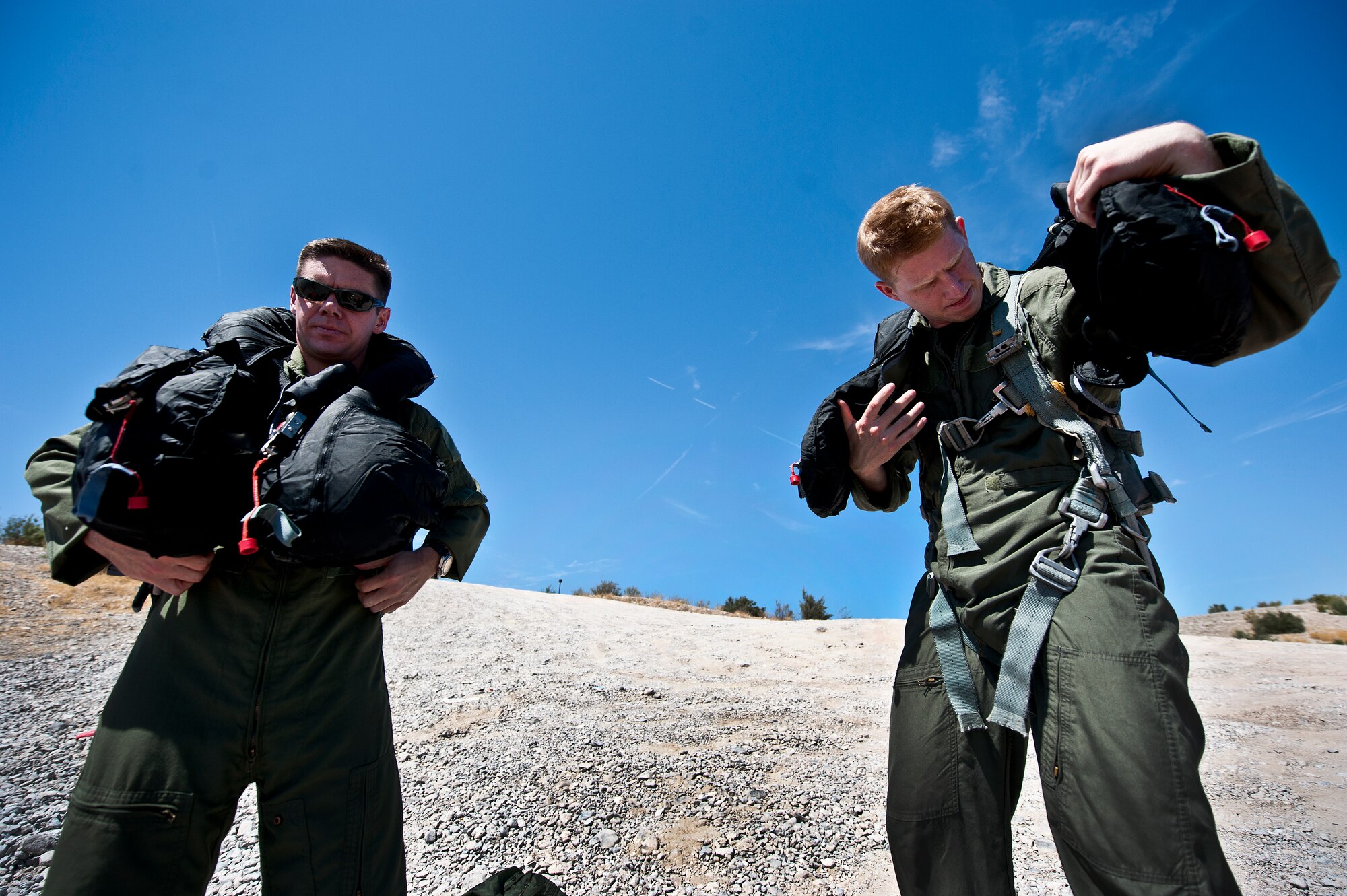 Left to right, U.S. Air Force Maj. Jeff Cannon, 57th Weapons Support Squadron, F-15E Strike Eagle pilot, and Capt. Justin Elliot, 422nd Test and Evaluation Squadron, F-15E Strike Eagle Division pilot, Nellis Air Force Base, Nev., get their safety gear ready for the Survival, Evasion, Resistance and Escape water survival training course Aug. 17, 2011, at Lake Mead, Nev. SERE specialists train high risk aircrew and personnel to survive, evade, and return safely should they eject, bailout, or otherwise become isolated during combat, anywhere in the world. (U.S. Air Force photo by Airman 1st Class George Goslin/Released)


