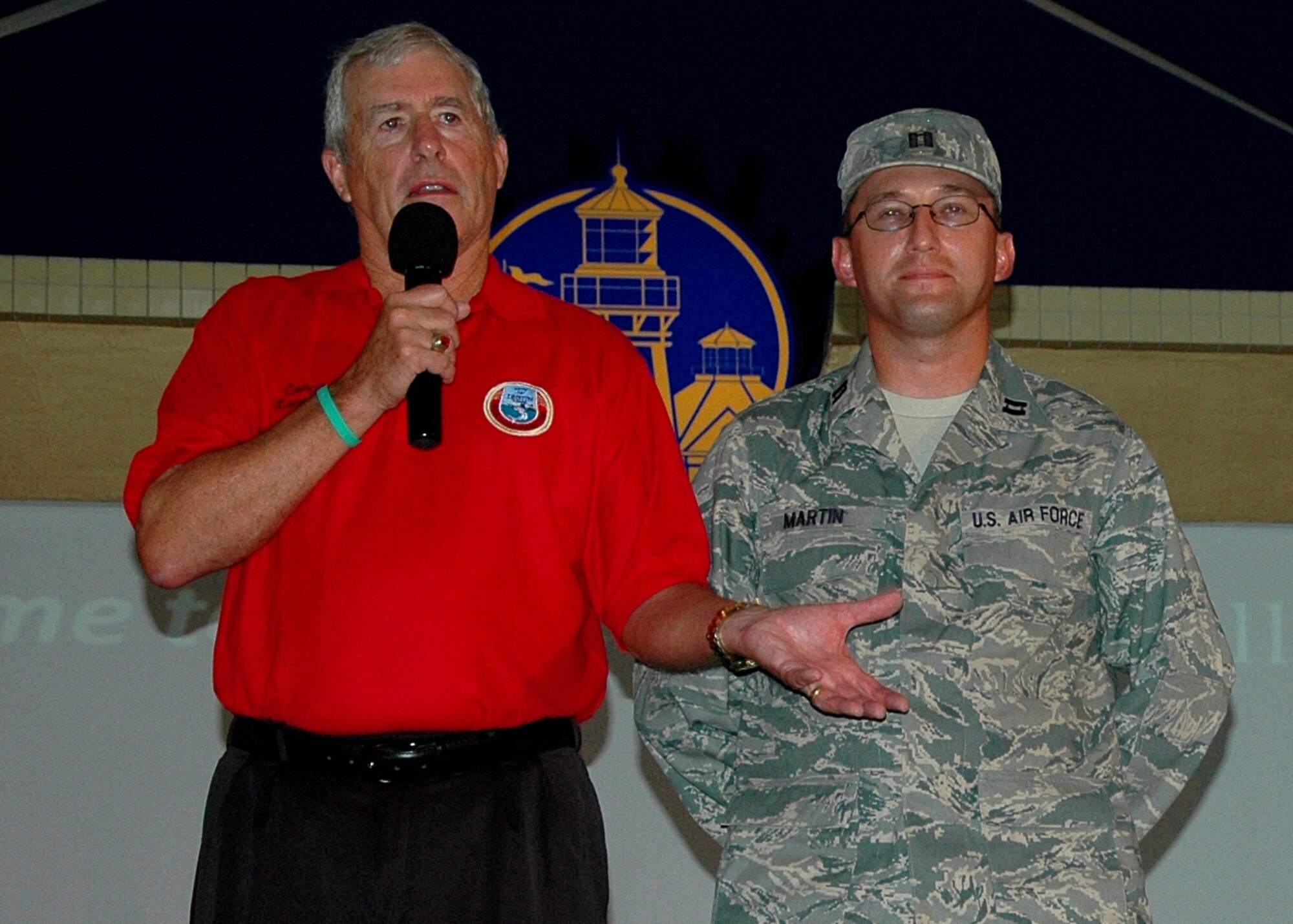 Capt. Mark Martin, representing the Air Force Research Lab, was honored at Destin's Red White and Blue Celebration Sept. 1. Larry Hines, a city council member, left, presented the officer a key to the city for his volunteer work with local charities. This was the last presentation to a Team Eglin member during the third annual summer-long festivity designed to pay tribute to local heroes and military members from the surrounding military communities. (U.S. Air Force photo by Randy Gon)