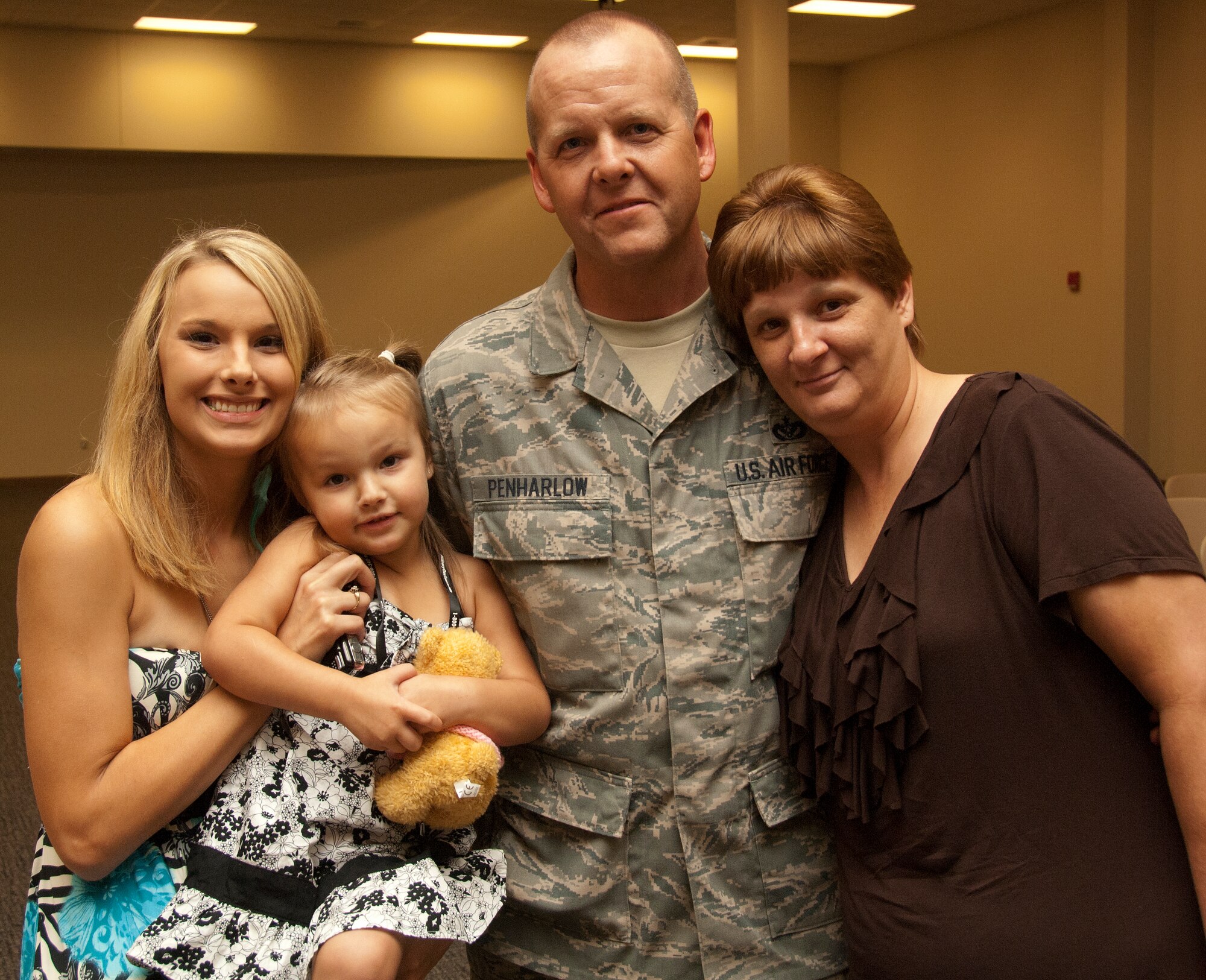 A dozen 403rd Wing civil engineers returning from a six-month deployment were reunited with their families at a reception in the Roberts Consolidated Maintenance Facility Sept. 1. Senior Airman Terry Penharlow was welcomed by (from left to right) daughter Brandy, granddaughter McKenzie and his wife, Beverly.  (U.S. Air Force photo by Master Sgt. Michael Duhe)