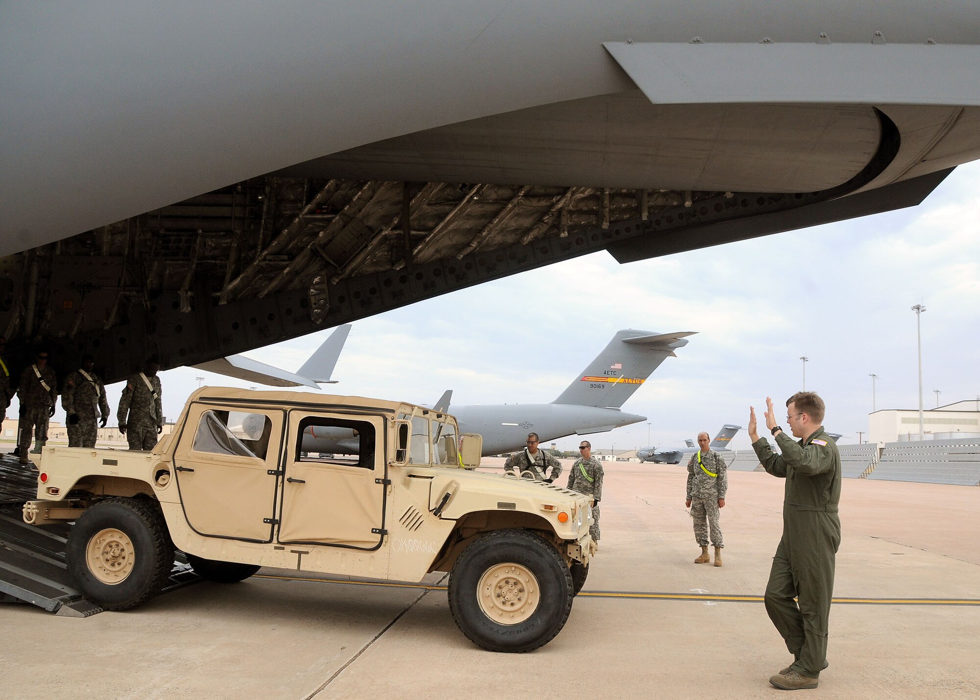 ALTUS AIR FORCE BASE, Okla. – Soldiers from the 168th Brigade Support Battalion, Fort. Sill, Okla. watch as Staff Sgt. Kyle Roen, 58th Airlift Squadron loadmaster, directs a HUMVEE up the ramp of a C-17 Globemaster III Aug. 30, 2011. The joint team of about 50 loaded 12 vehicles and six trailers of equipment on and off the aircraft about five times as part of a humanitarian relief preparation exercise. The goal of this exercise was to train and equip involved units to support the safety, security and survival needs of an area as a result of a natural disaster.  (U.S. Air Force photo by Staff Sgt. Marianne E. Lane/ 97th Air Mobility Wing Public Affairs-Released)