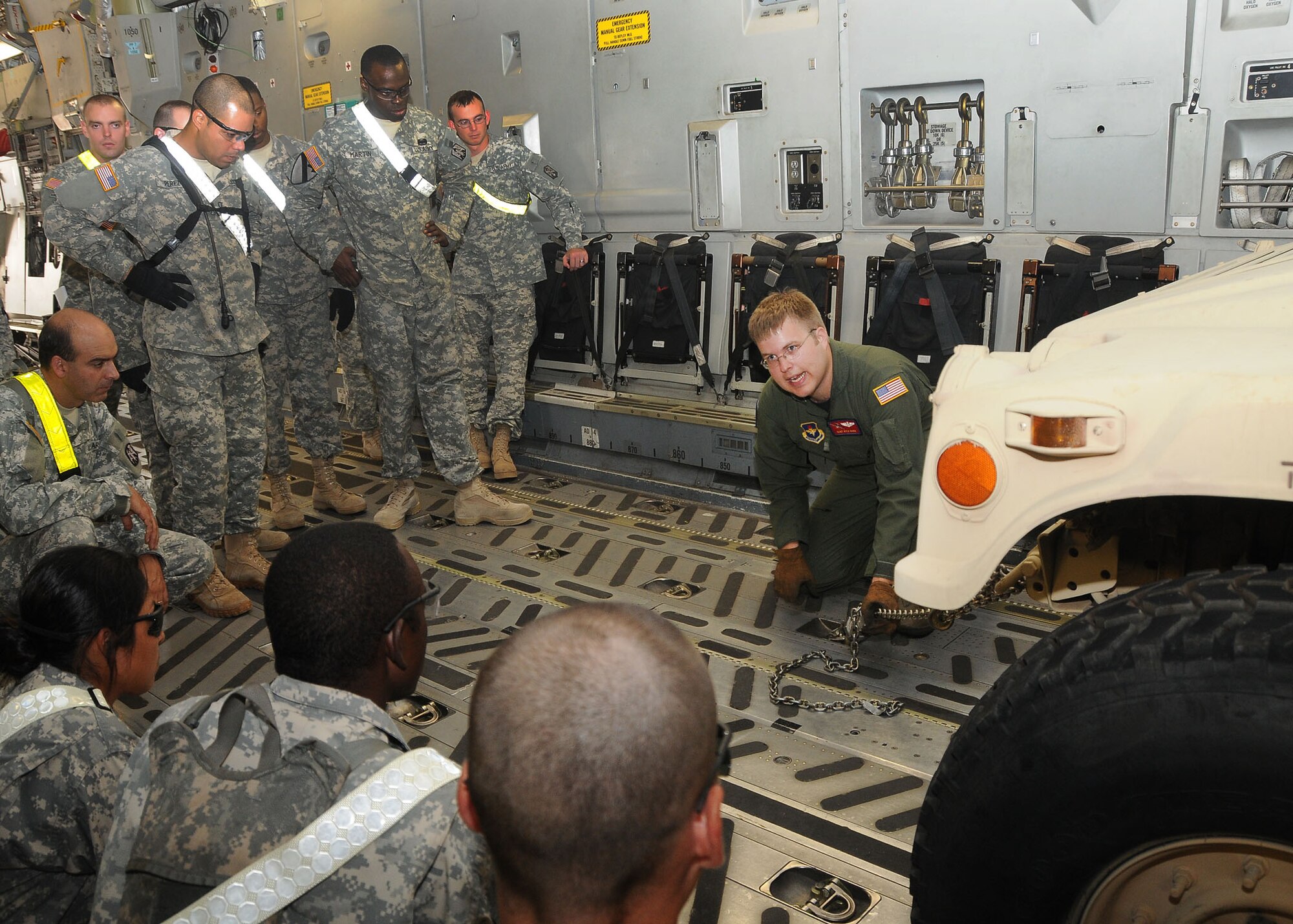 ALTUS AIR FORCE BASE, Okla. – Soldiers from the 168th Brigade Support Battalion, Fort Sill, Okla. are trained on how to secure vital assets in a C-17 Globemaster III by Staff Sgt. Kyle Roen, 58th Airlift Squadron loadmaster, during a humanitarian relief preparation exercise Aug. 30, 2011. The joint team of about 50 loaded 12 vehicles and six trailers of equipment on and off a C-17 Globemaster III about five times. The goal of this exercise was to train and equip involved units to support the safety, security and survival needs of an area as a result of a natural disaster.  (U.S. Air Force photo by Staff Sgt. Marianne E. Lane/ 97th Air Mobility Wing Public Affairs-Released)