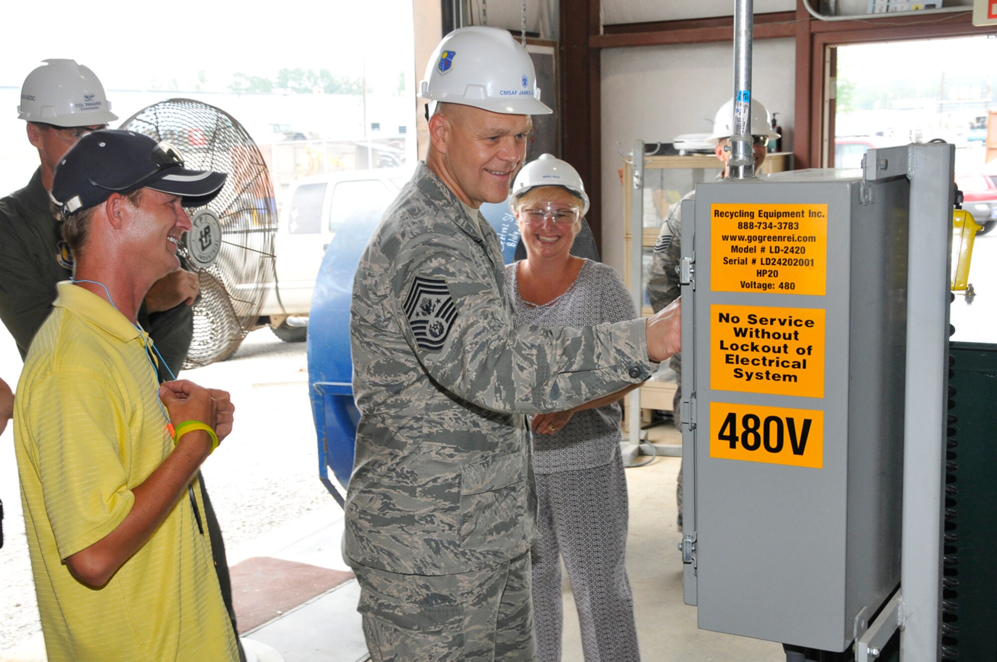 Chief Master Sgt. of the Air Force James Roy gets a hands-on look at AEDC’s recycling facilities as his wife Paula watches during a base tour July 15. Also pictured is Robbie Evans Jr., recycling facility manager. Chief Roy, the highest enlisted leader in the Air Force, also spoke to the work force during his visit. (Photo by Rick Goodfriend)
