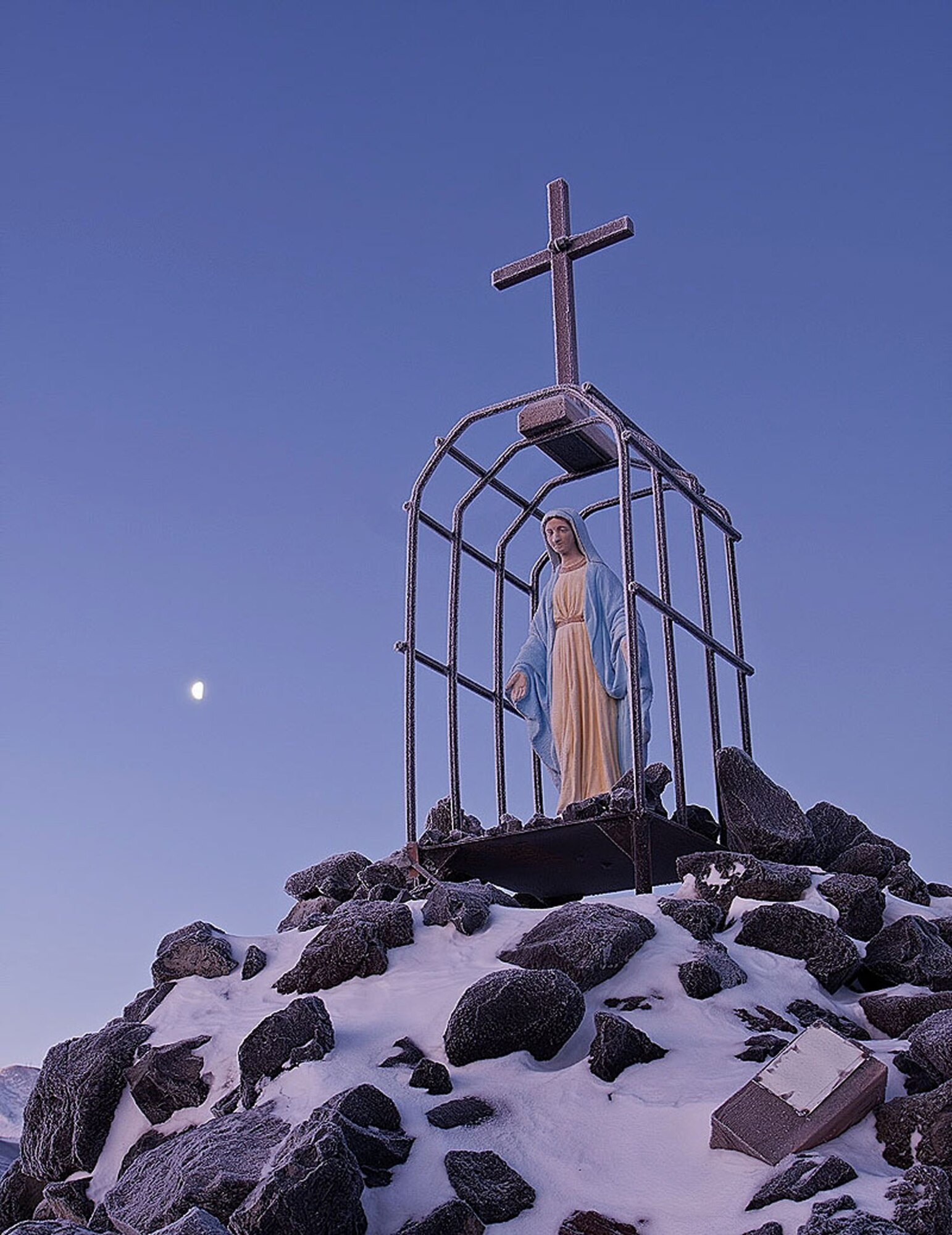 In a final pilgrimage to pay his respects to a fellow civil engineer, Chief Master Sgt. Michael Beck left a gift at the feet of "Our Lady of the Snows Shrine" at McMurdo Station, Antarctica. More fondly known as "Roll Cage Mary" because of the structure built to protect her from the elements, this statue of the Virgin Mary watches over all souls that were lost during the building of the station, but is dedicated to one. A bronze plaque nearby remembers the tragic death, while in the line of duty, of Construction Driver 3rd Class Richard T. Williams, U.S. Navy Seabees. He lost his life when his D-8 tractor broke through the ice in 1956, during "Operation Deep Freeze I." He plunged 350 fathoms to the bottom of McMurdo Sound, his body never recovered. (Courtesy photo)