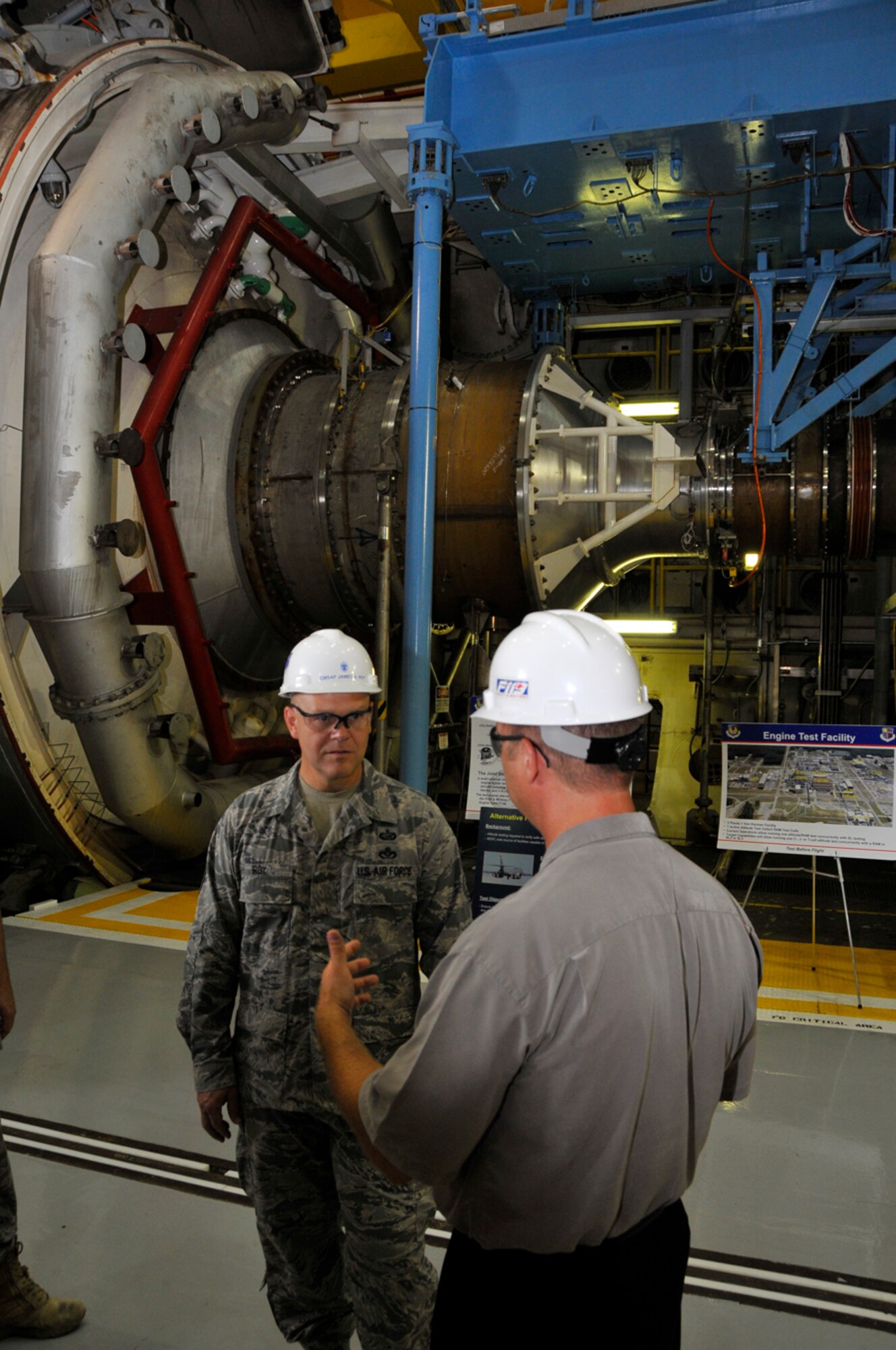 Chief Master Sgt. of the Air Force James Roy, left, learns about AEDC’s Aeropropulsion Systems Test Facility from John Kelly, an aeropropulsion project manager, and one of the base’s few U.S. Navy civilian employees. Chief Roy and his wife visited the base July 15. The chief represents the highest enlisted level of leadership in the Air Force and represents the interests of the enlisted force. (Photo by Rick Goodfriend)
