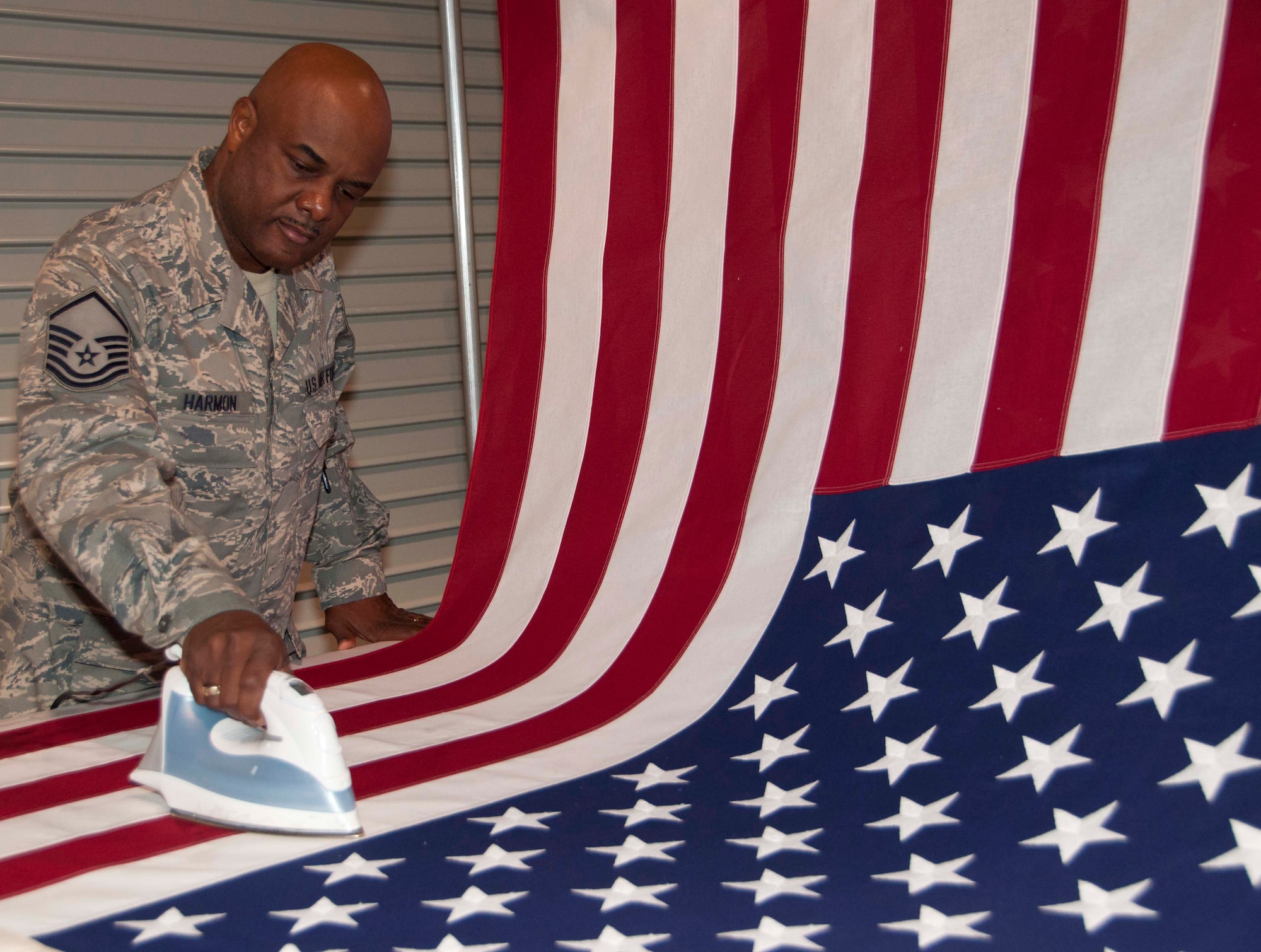 Master Sgt. Tony Harmon, Departures noncommissioned officer in charge, presses a flag at the Charles C. Carson Center for Mortuary Affairs Sept. 2, 2011. As the nation prepares to celebrate Labor Day, the sacred mission of honoring the fallen continues behind closed doors. For Harmon, it is a labor of love. He has deployed to the mortuary more than 10 times to support the mission. Harmon is a reservist with the 512th Memorial Affairs Squadron, Dover Air Force Base, Del. (U.S. Air Force photo/Christin Michaud)
