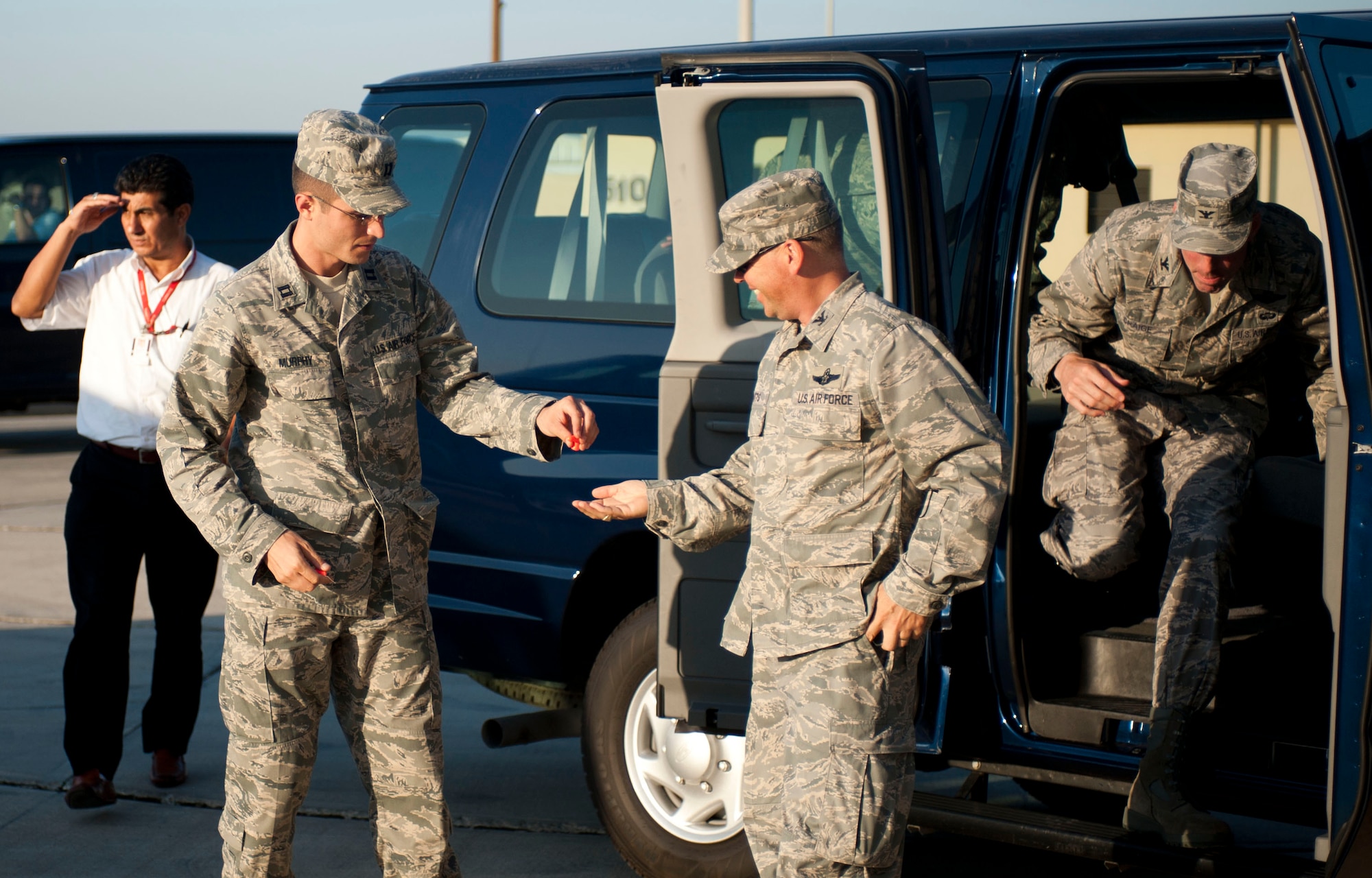 Capt. Jonathan Murphy, 39th Air Base Wing chief of protocol, hands ear plugs to Col. Chad Butts, 39th Air Base Wing vice commander, before greeting a distinguished visitor Aug. 24, 2011, on the flightline at Incirlik Air Base, Turkey. (U.S. Air Force photo by Airman 1st Class Clayton Lenhardt/Released)