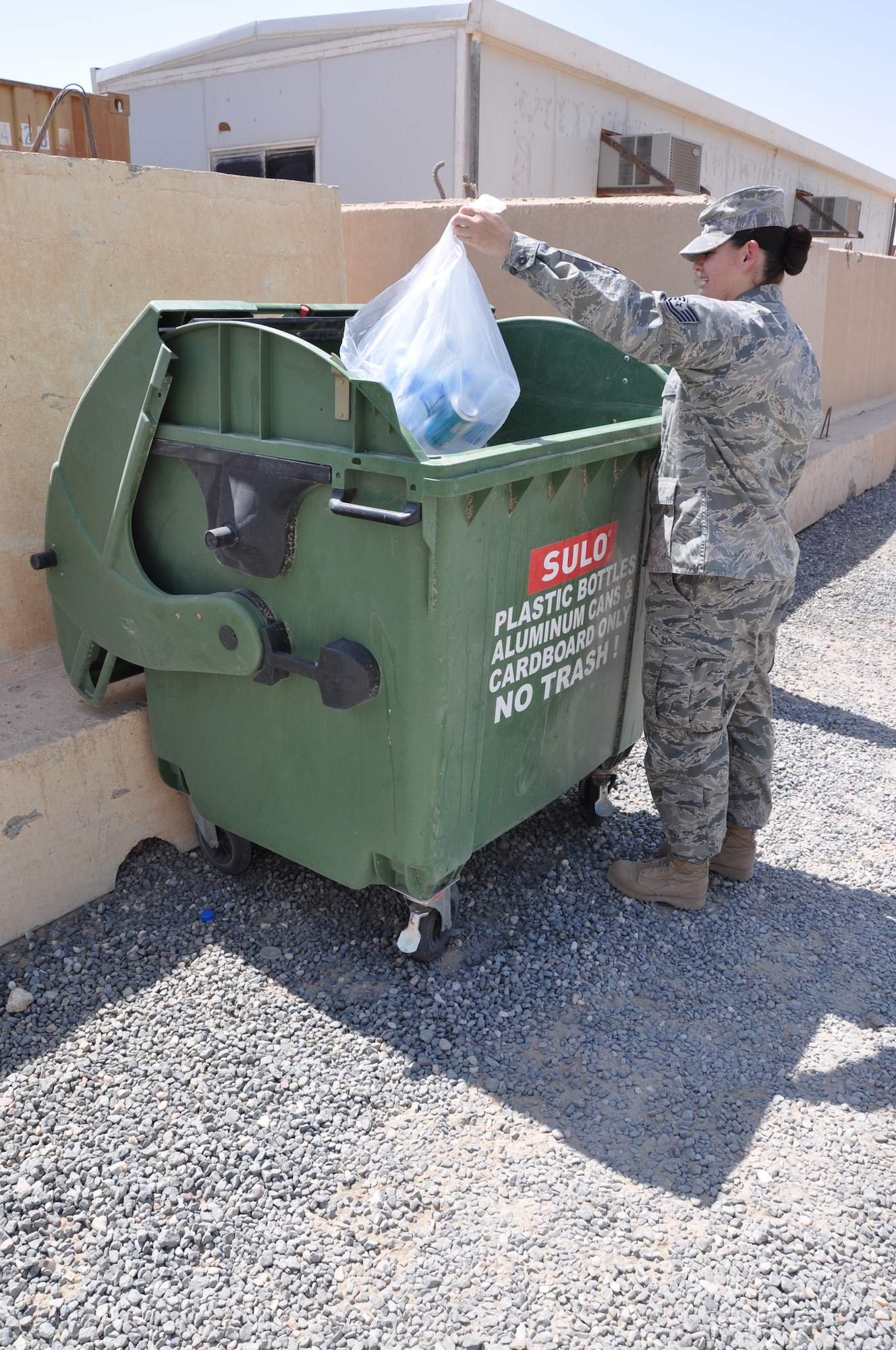 Technical Sgt. Tennille Benton, 386th Air Expeditionary Wing NCOIC of Protocol, recycles a a bag of bottles and cans Sept. 2 at an undisclosed loaction in Southwest Asia. (U.S. Air Force photo by Senior Airman Rachelle Elsea)