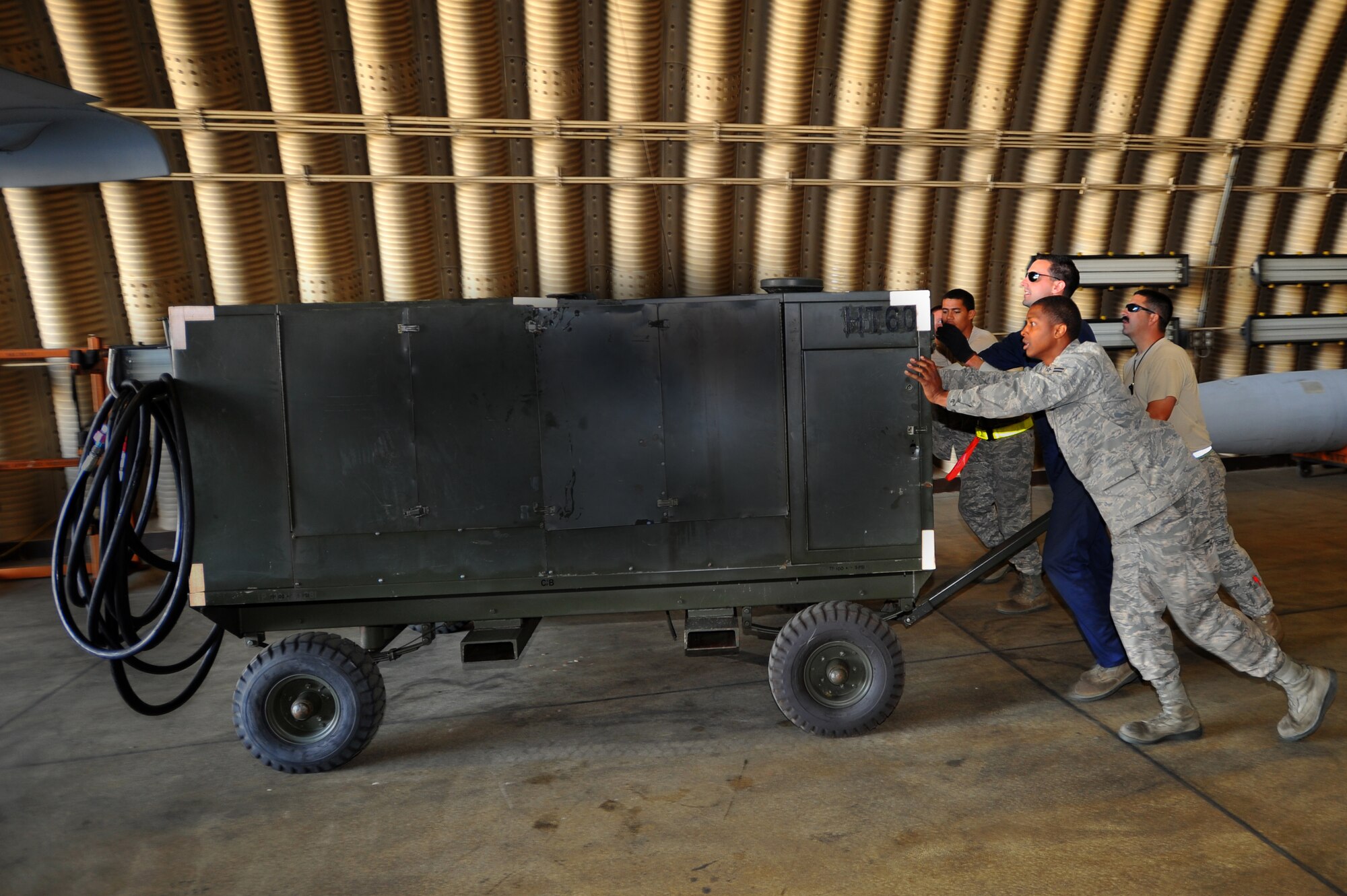 SPANGDAHLEM AIR BASE, Germany – Airmen from the 81st Aircraft Maintenance Unit push a hydraulic fluid draining pump out of a hangar here Aug. 30. The 81st AMU delivers precise and reliable maintenance to continually support the capabilities of the 81st Fighter Squadron’s flying mission. (U.S Air Force photo/Airman 1st Class Dillon Davis)