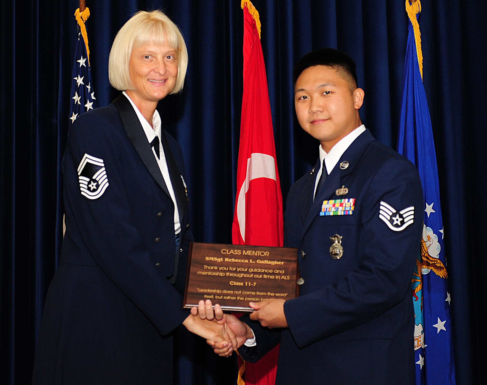 Staff Sgt. Billy Lei, 425th Air Base Squadron, Izmir Air Station, right, presents Senior Master Sgt. Rebecca Gallagher, 39th Operations Squadron, with a plaque thanking her for her leadership as the class mentor during the airman leadership school graduation for Class 11-7 Sept. 1, 2011, in the Club Complex at Incirlik Air Base, Turkey. Lei, class leader, recieved the John L. Levitow Award, which is the highest award presented at ALS. (U.S. Air Force photo by Senior Airman Anthony Sanchelli/Released)
