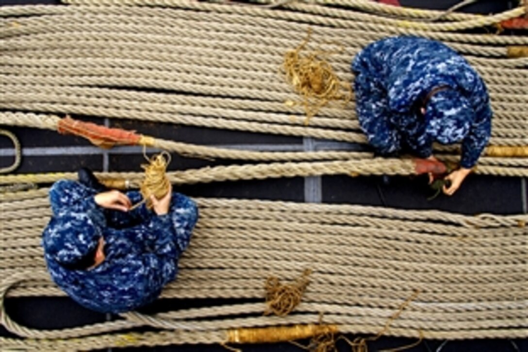 Sailors assigned to the amphibious assault ship USS Bonhomme Richard perform maintenance on mooring lines off the coast of San Diego, Aug. 30, 2011.