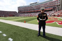 Sgt. Joshua Benne, stands on the field at Memorial Stadium. Benne is a Lincoln native and combat veteran honored at Opening Day. Benne runs the Recruiting Sub-station in Dubuque, Iowa.