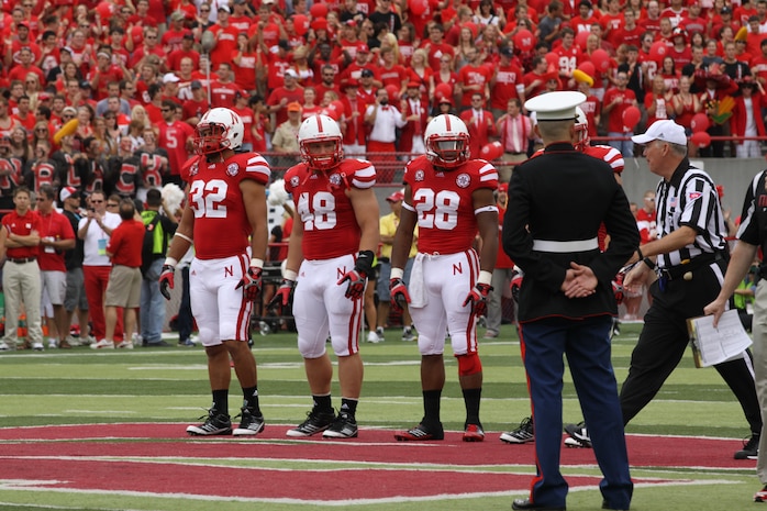 Sgt. Joshua Benne, joins the team captains for the ceremonial coin-toss at Memorial Stadium. Sgt. Benne is a Lincoln native and combat veteran honored at Opening Day. Benne runs the Recruiting Sub-station in Dubuque, Iowa.