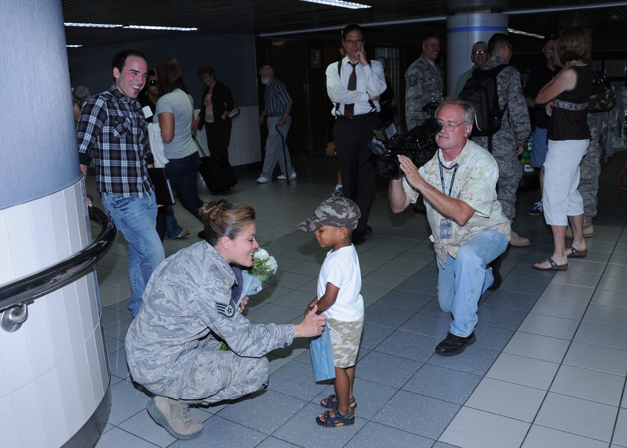 Sidewinder vocalist Staff Sgt. Angie Johnson chats with a child of a band member while local news media looks on.  Members of Sidewinder returned to Saint Louis Sept 3 from their 45-day deployment to Southwest Asia where they performed for numerous troops in Iraq, Afghanistan, and throughout the region.  Sidewinder is the rock element of the 571st Air Force Band "Air National Guard Band of the Central States" based at the 131st Bomb Wing, Missouri Air National Guard, Lambert-Saint Louis.  Their rendition of "Rolling in the Deep" by Adele became a You Tube sensation and has been viewed over 1.3 million times.  (Photo by Master Sgt. Mary-Dale Amison)
