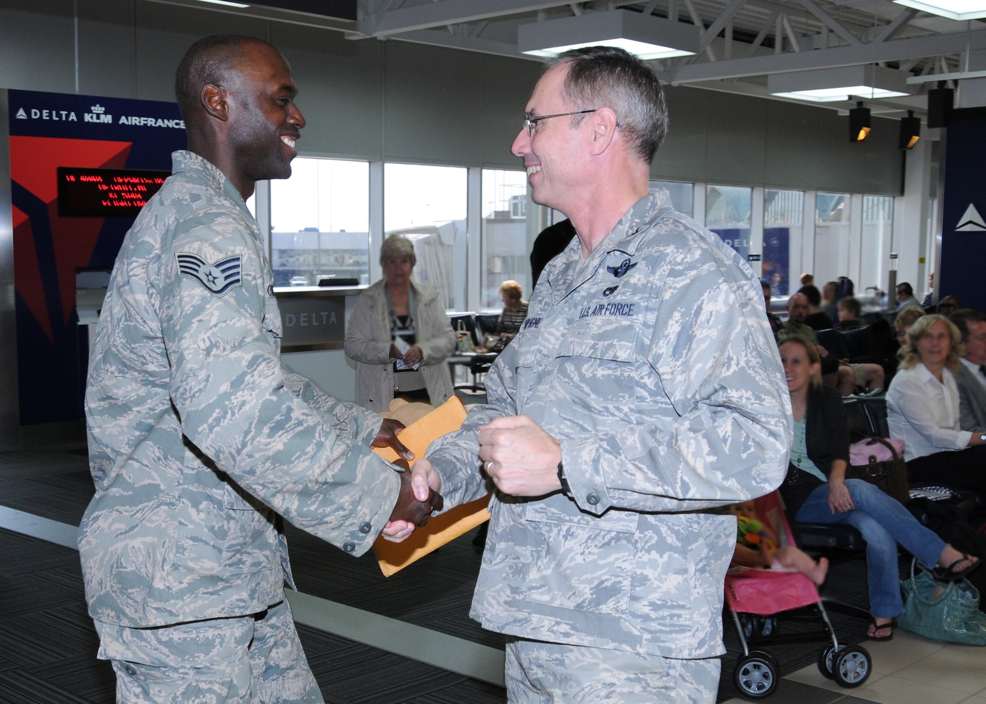 Colonel Greg Champagne, 131st Bomb Wing Commander, Missouri Air National Guard, greets Sidewinder vocalist SSgt Brian Owens as he arrives at Lambert Airport, Sept 3.  Members of Sidewinder returned to Saint Louis from their 45-day deployment to Southwest Asia where they performed for numerous troops in Iraq, Afghanistan, and throughout the region.  Sidewinder is the rock element of the 571st Air Force Band "Air National Guard Band of the Central States" based at the 131st Bomb Wing, Missouri Air National Guard, Lambert-Saint Louis.  Their rendition of "Rolling in the Deep" by Adele became a You Tube sensation and has been viewed over 1.3 million times.  (Photo by Master Sgt. Mary-Dale Amison)