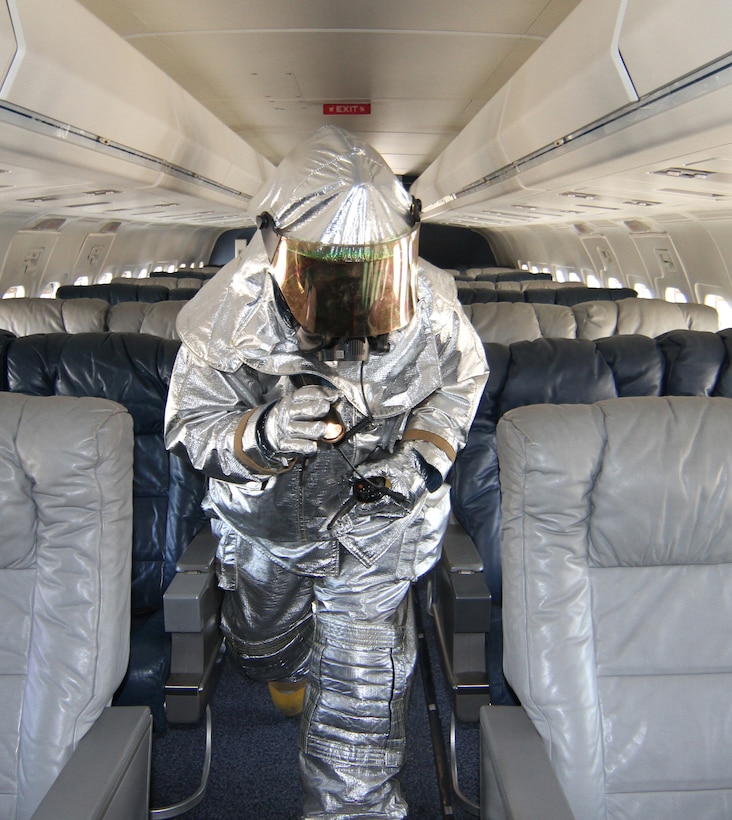 Usually a flight attendant is walking up and down the aisle checking on distinguished visitors; however on a recent drill weekend, a 932nd Airlift Wing firefighter walks through the cabin of the C-40C looking for anyone that may need help during an exercise to test first responder response times to emergencies.  (U.S. Air Force photo/Tech. Sgt. Chris Parr)