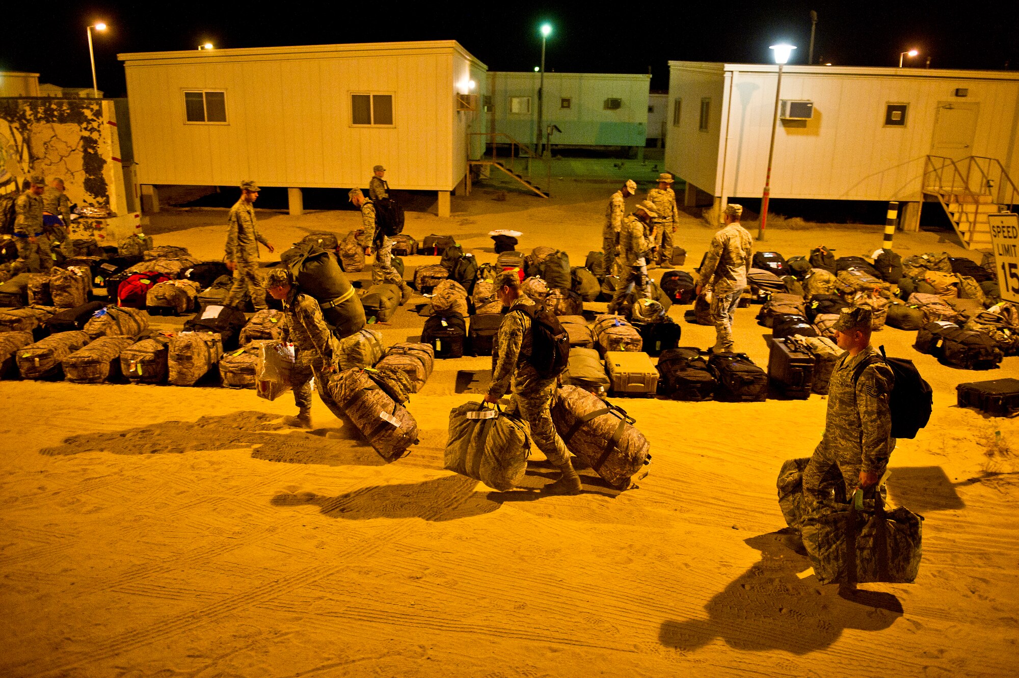 Airmen assigned to the 332nd Air Expeditionary Group carry their bags to their lodging rooms after arriving in the middle of the night on Aug. 31, 2011. The Airmen a part of a group that deployed to Southwest Asia to support Operation New Dawn. (U.S. Air Force Photo/Master Sgt. Jeffrey Allen)