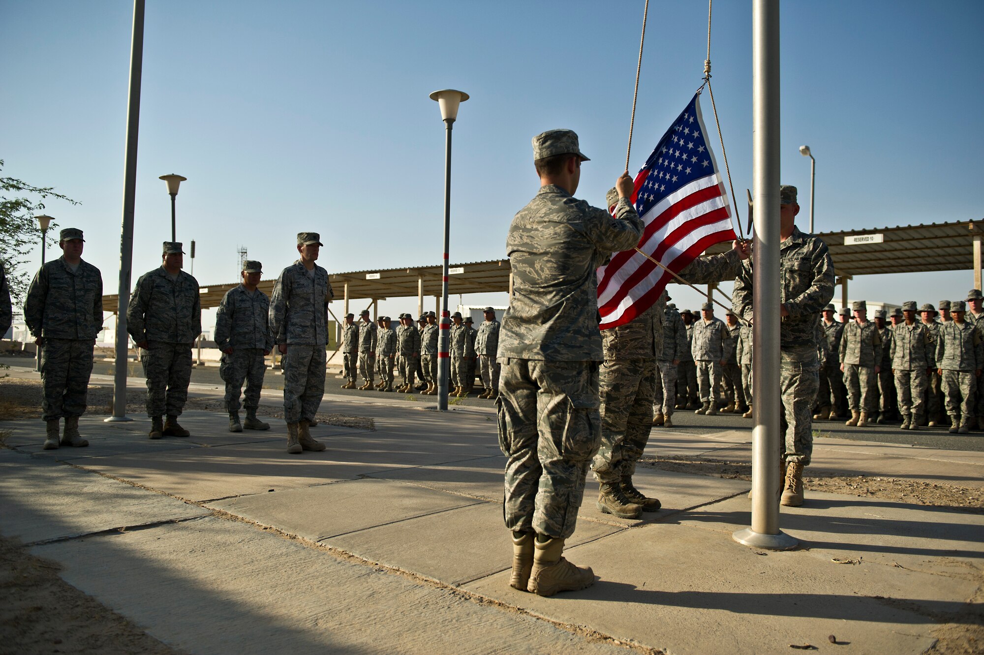 Airmen from the 332nd Civil Engineer Squadron raise the American flag Aug. 31, 2011 at a base in Southwest Asia for the first time since it closed several years ago. Airmen are cleaning and repairing base infrastructure in order to conduct missions supporting Operation New Dawn. (U.S. Air Force Photo/Master Sgt. Jeffrey Allen)