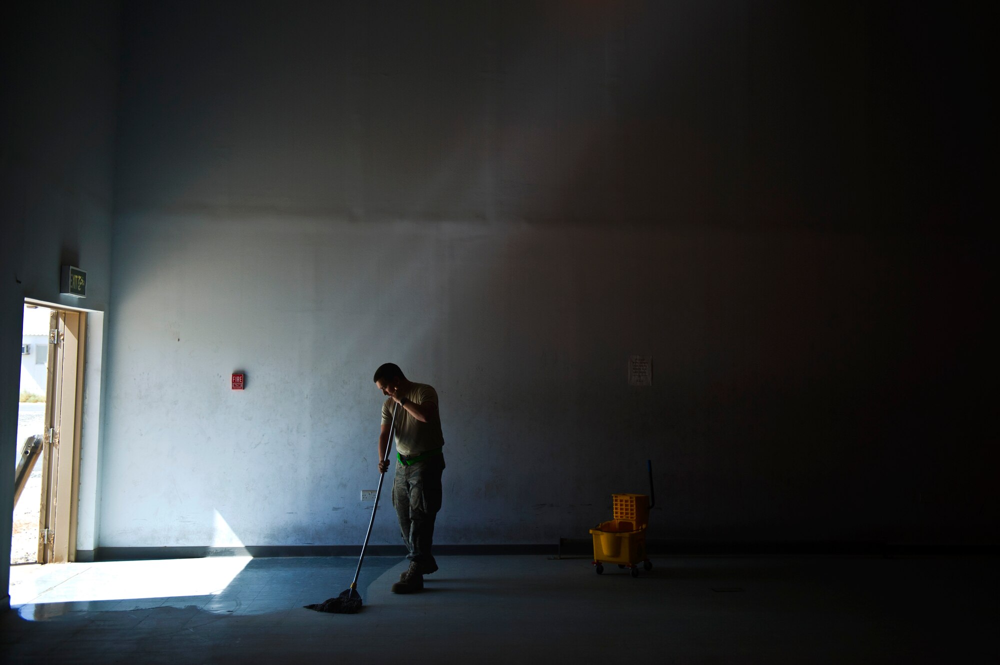 Airman 1st Class, Nicolas Peterson, 570th Contingency response Group, Travis AFB, CA, mops the floor of the gym at an Air Base in Southwest Asia on Aug. 25, 2011. The gym and other buildings around the base are being cleaned in order to support follow-on troops that will be deployed there. The base, which closed in 2004, is being re-opened to conduct missions supporting Operation New Dawn.  (U.S. Air Force Photo/Master Sgt. Jeffrey Allen)