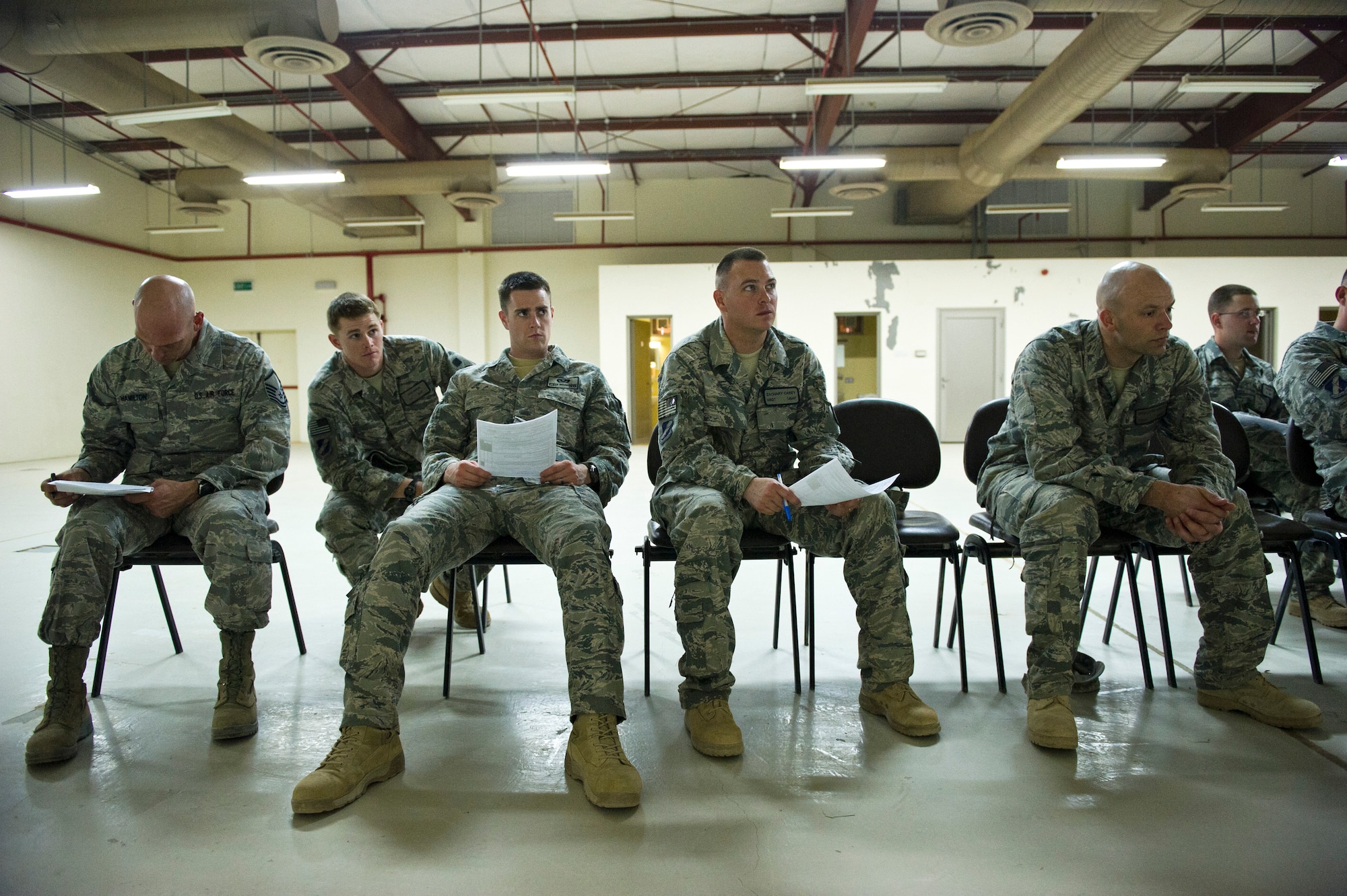 Members of the 467th Expeditionary Civil Engineer Squadron receive a briefing after there arrival at an undisclosed location in Southwest Asia on Aug. 23, 2011. The Airmen are part of the initial group of personnel tasked with re-opening a base that has been closed since 2004. Once open the base will conduct missions supporting Operation New Dawn. (U.S. Air Force Photo/Master Sgt. Jeffrey Allen)