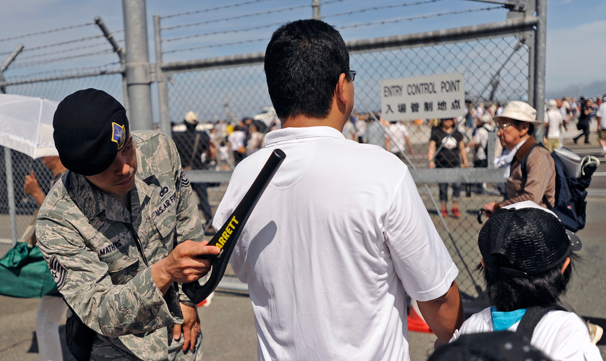 MISAWA AIR BASE, Japan -- 35th Security Forces Squadron Tech. Sgt. Dennis Mathys randomly scans attendees at the 2011 Air Fest entry point here Sept 4. The Japan Air Self-Defense Force (JASDF) and the 35th Fighter Wing, with associated tenant units, hosted more than 100,000 attendees at Misawa's 32nd Annual air fest Sept. 4. Air Fest 2011 was an opportunity for visitors to see eight aerial demonstrations with 19 static displays of JASDF, U.S. Air Force, U.S. Navy aircraft and private operators. Air Fest 2011 also marked the last flight of Miss Veedol, a single engine aircraft that in 1931 flew non-stop across the Pacific Ocean from Sabishiro Beach, Misawa, Japan to Wenatchee, Washington, U.S. (U.S. Air Force photo by Master Sgt. Maria J. Bare)