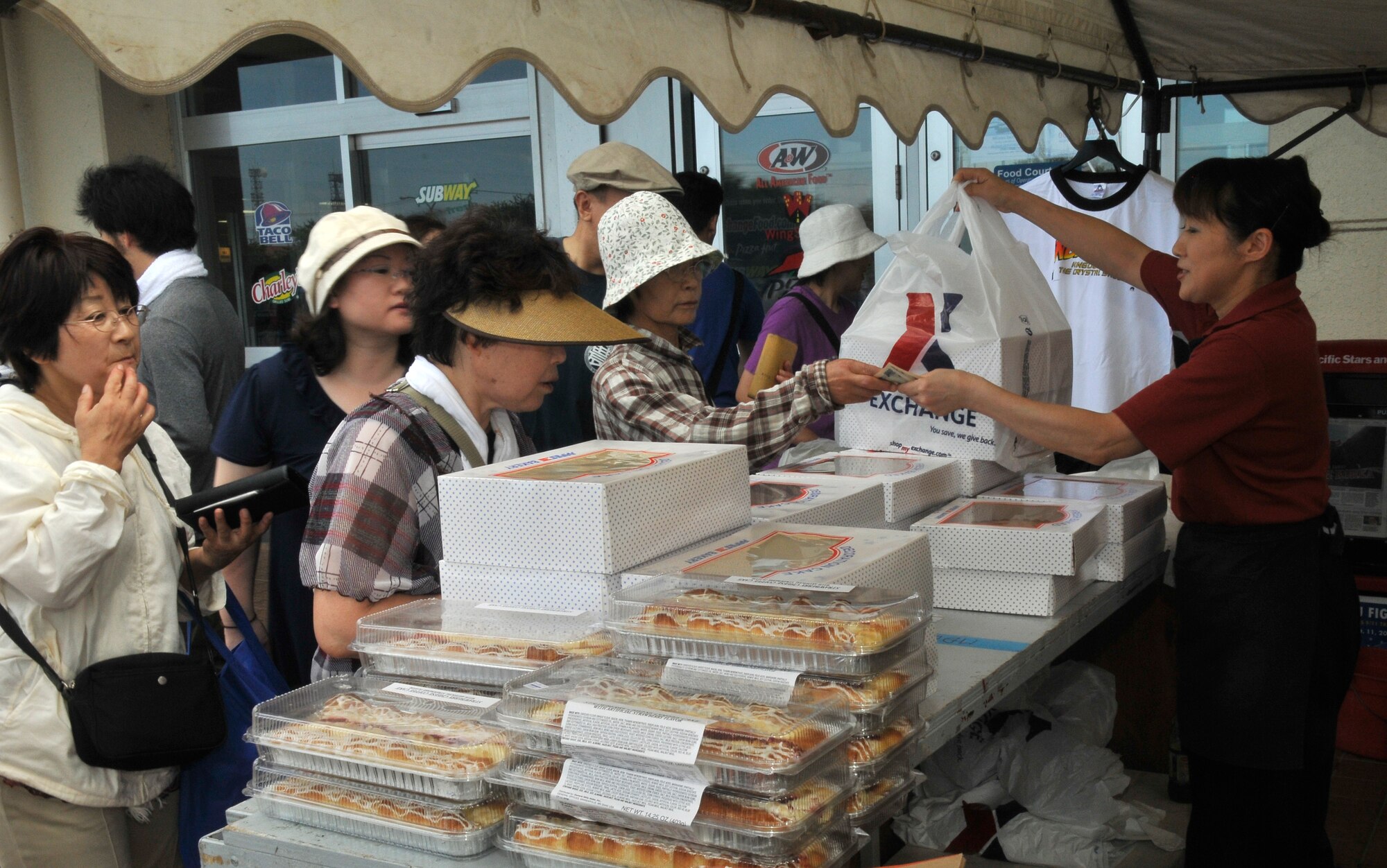 MISAWA AIR BASE, Japan— Mieko Hayase, completes a transaction with a Japanese National attending the 32nd annual Misawa Air Fest here Sept. 4. Hamburgers, pizzas and cakes were the most sought after items for sale during the air fest. The Japan Air Self-Defense Force and the 35th Fighter Wing, with associated tenant units, hosted more than 100,000 attendees at the fest where visitors saw eight aerial demonstrations with 19 static displays of JASDF, U.S. Air Force, U.S. Navy aircraft and private operators. Air Fest 2011 also marked the last flight of Miss Veedol, a single engine aircraft that in 1931 flew non-stop across the Pacific Ocean from Sabishiro Beach, Misawa, Japan to Wenatchee, Washington, U.S. (U.S. Air Force photo/Tech. Sgt. Phillip Butterfield)  