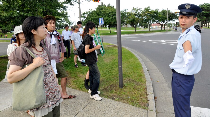 MISAWA AIR BASE, Japan – Japan Air Self-Defense Force Airman Basic Masoki Nasio, directs traffic here Sept. 4. The Japan Air Self-Defense Force and the 35th Fighter Wing, with associated tenant units, hosted more than 100,000 attendees at Misawa's annual air fest. Air Fest 2011 was an opportunity for visitors to see eight aerial demonstrations with 19 static displays of JASDF, U.S. Air Force, U.S. Navy aircraft and private operators. Air Fest 2011 also marked the last flight of Miss Veedol, a single engine aircraft that in 1931 flew non-stop across the Pacific Ocean from Sabishiro Beach, Misawa, Japan to Wenatchee, Washington, U.S. (U.S. Air Force photo/Tech. Sgt. Phillip Butterfield)  