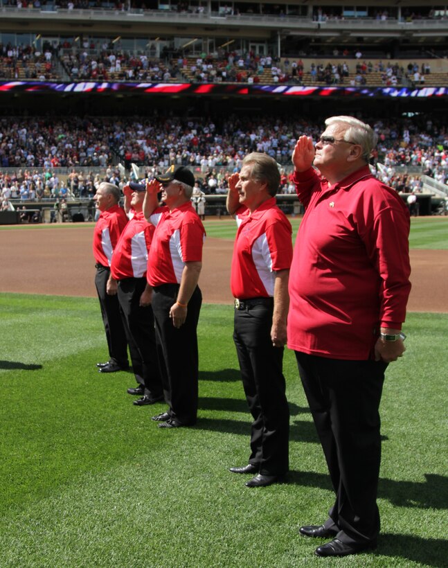 Six members of the original 1967 Twins Platoon salute to the playing of the National Anthem during a pregame ceremony where 24 local young men and women were sworn in to the U.S. Marine Corps, at Target Field, Sept. 5.