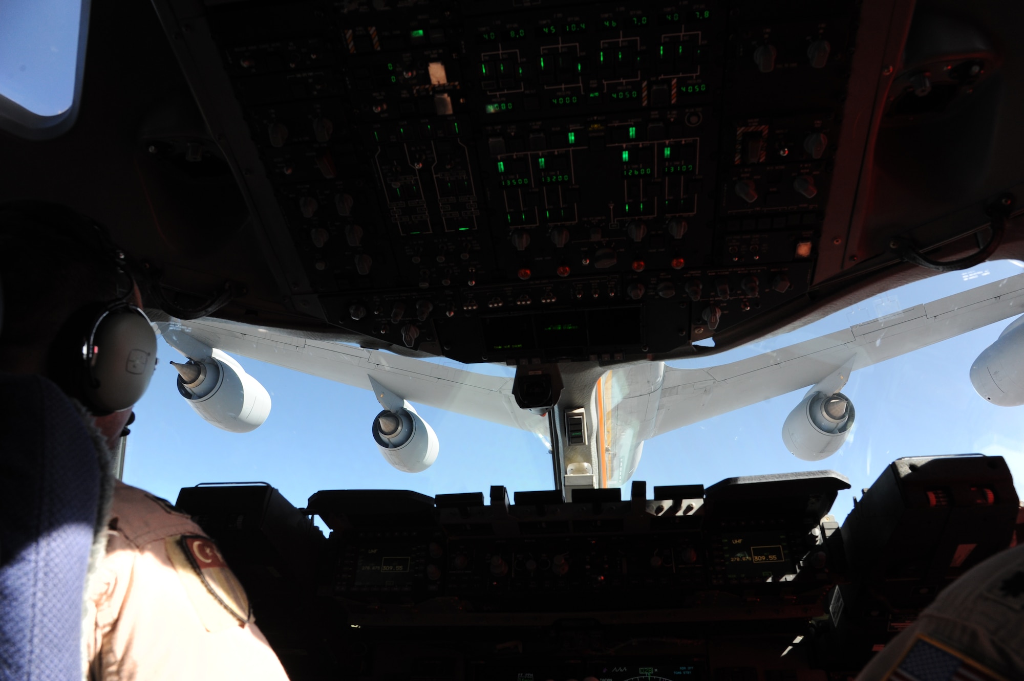 A KC-135 Stratotanker is visible through the cockpit window as it refuels a C-17 Globemaser III during an aerial refueling operation in the skies over Kyrgyzstan Sept. 2. The refueling mission was part of an orientation flight designed to showcase aerial refueling procedures to key personnel at the Kyrgyz Ministry of Transportation and Communication, the Civil Aviation Agency, the Manas International Airport and the Kyrgyz Air Navigation military sector. (U.S. Air Force photo/Tech. Sgt. Hank Hoegen) 