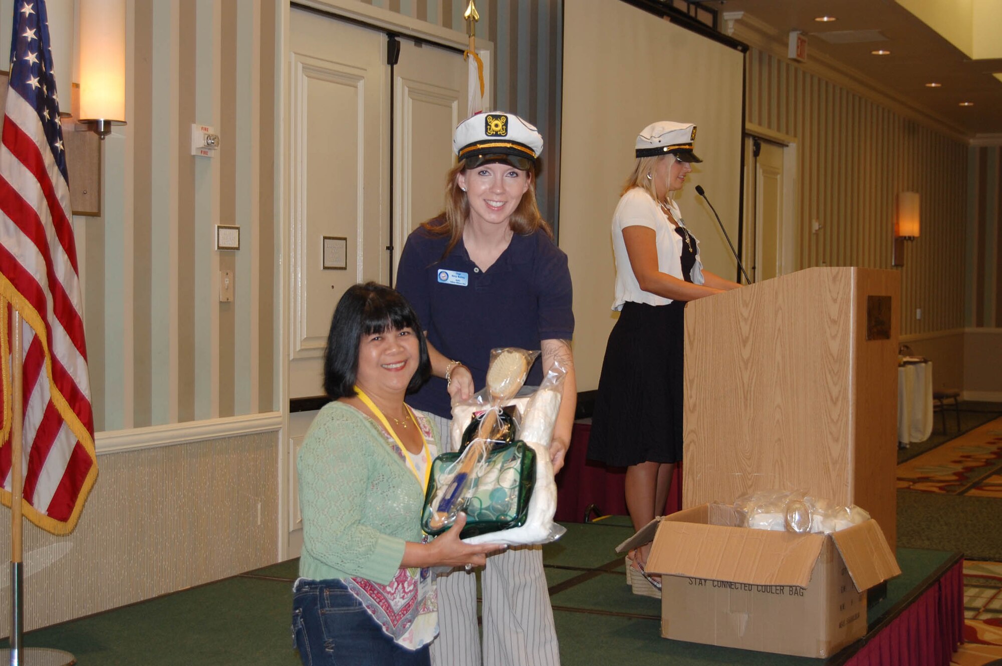 (Center) Tech. Sgt. Amy Bailey, 926th Force Support Squadron noncommissioned officer in charge of family readiness and Yellow Ribbon Program Coordinator, presents a donated gift basket to a military spouse (left) during a raffle at the Yellow Ribbon event in San Diego, Calif., on Aug. 28.