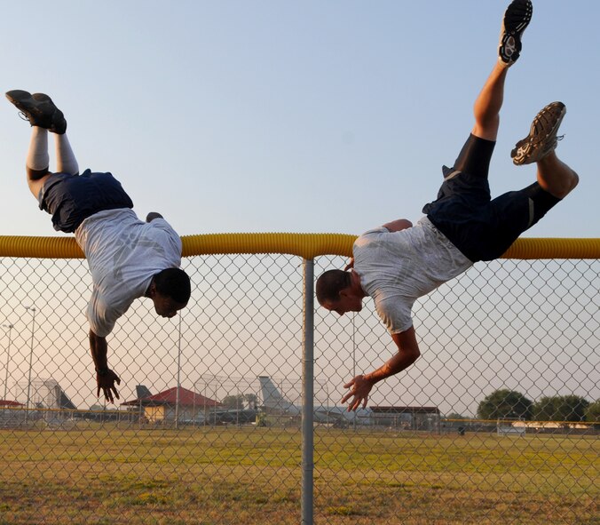 Staff Sgt. Eric Murphy and Airman 1st Class Dustin Gallimore, 2nd Security Forces Squadron, vault over a fence during tryouts for the 2 SFS Global Strike Challenge team at Barksdale Air Force Base, La., Sept. 1. The Airmen trying out for the team endure rigorous tests to evaluate their fitness, land navigation skills and marksmanship. (U.S. Air Force photo/2nd Lt. Tori Lalich)(RELEASED)