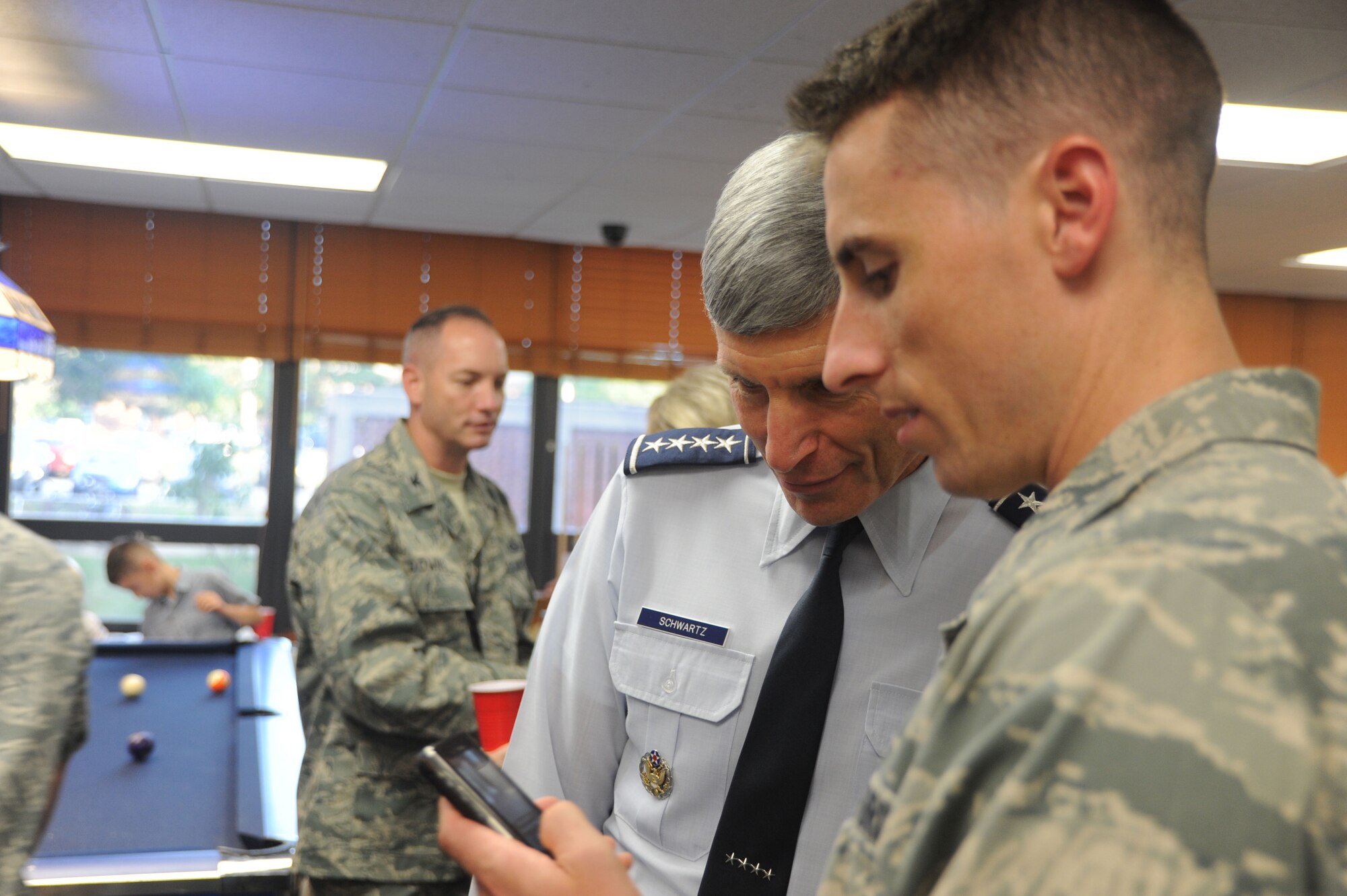 Air Force Chief of Staff Gen. Norton Schwartz looks at a photo with Airman 1st Class Jarred Adams, from the 70th Intelligence, Surveillance and Reconnaissance Wing, during a dorm dinner Aug. 31 at Fort George G. Meade, Md. (U.S. Air Force photo/Staff Sgt. Dillon White)