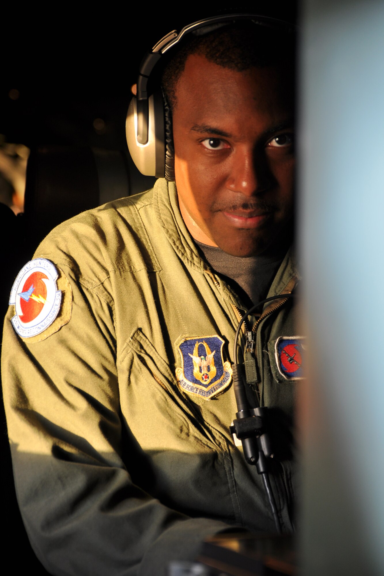 Staff Sgt. Larry Banks, a weather reconnaissance loadmaster with the 53rd Weather Reconnaissance Squadron, looks around the side of the computer to ensure everything is ready to go before penetrating Tropical Storm Lee Sept. 2. Banks collects and records vertical meteorlogical data from a parachute-borne sensor known as a dropsonde. (U.S. Air Force photo by Staff Sgt. Valerie Smock)