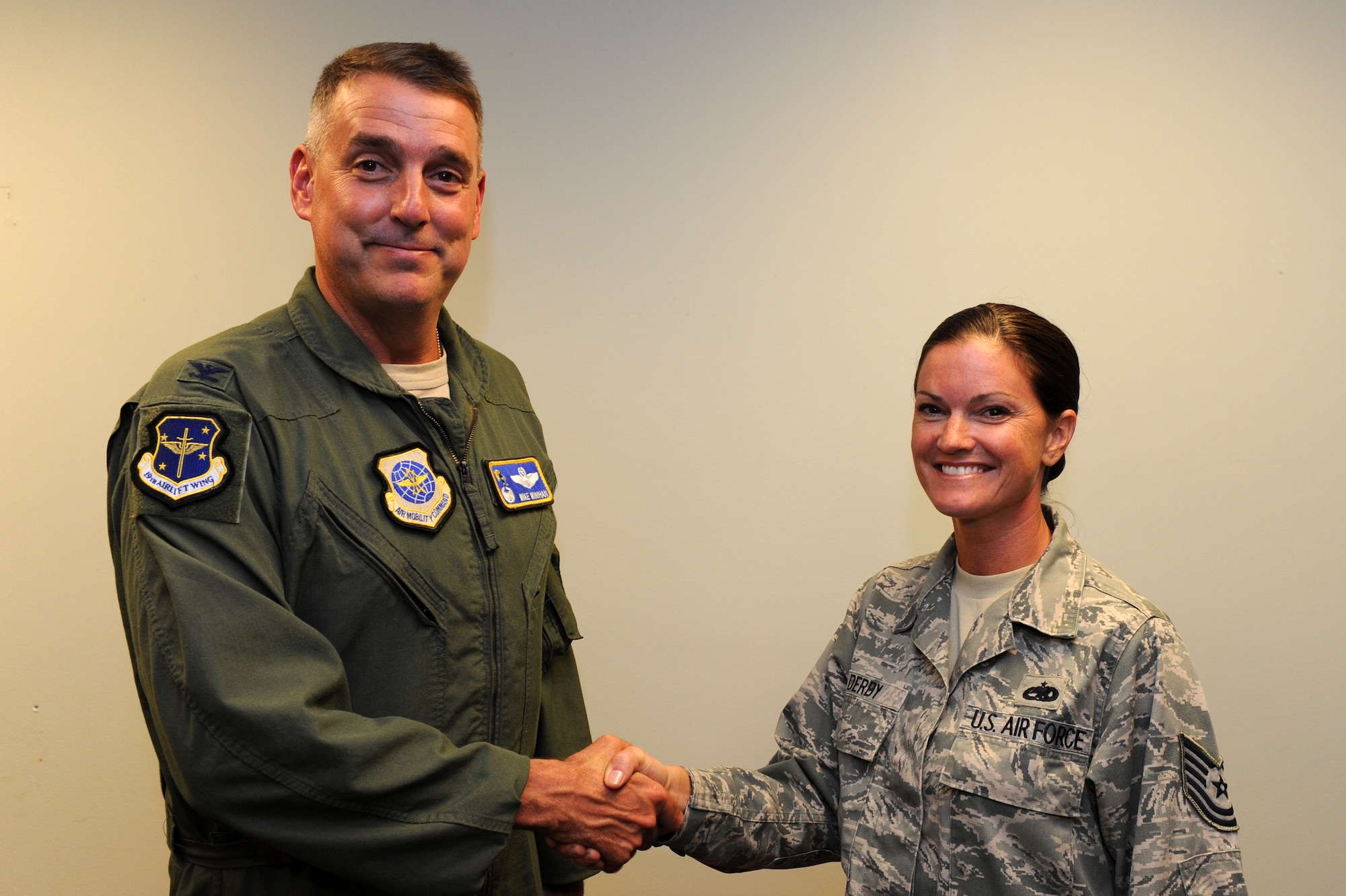 Col. Mike Minihan, 19th Airlift Wing commander, presents a commander’s coin Aug. 29, 2011, to Tech. Sgt. Dana Derby, a 19th Maintenance group quality assurance inspector, for her selection as Combat Airlifter of the Week. She developed operational readiness exercise scenario injects to test mission essential capabilities strengthening the wing’s war fighting skills. (U.S. Air Force photo by Airman 1st Class Rusty Frank)