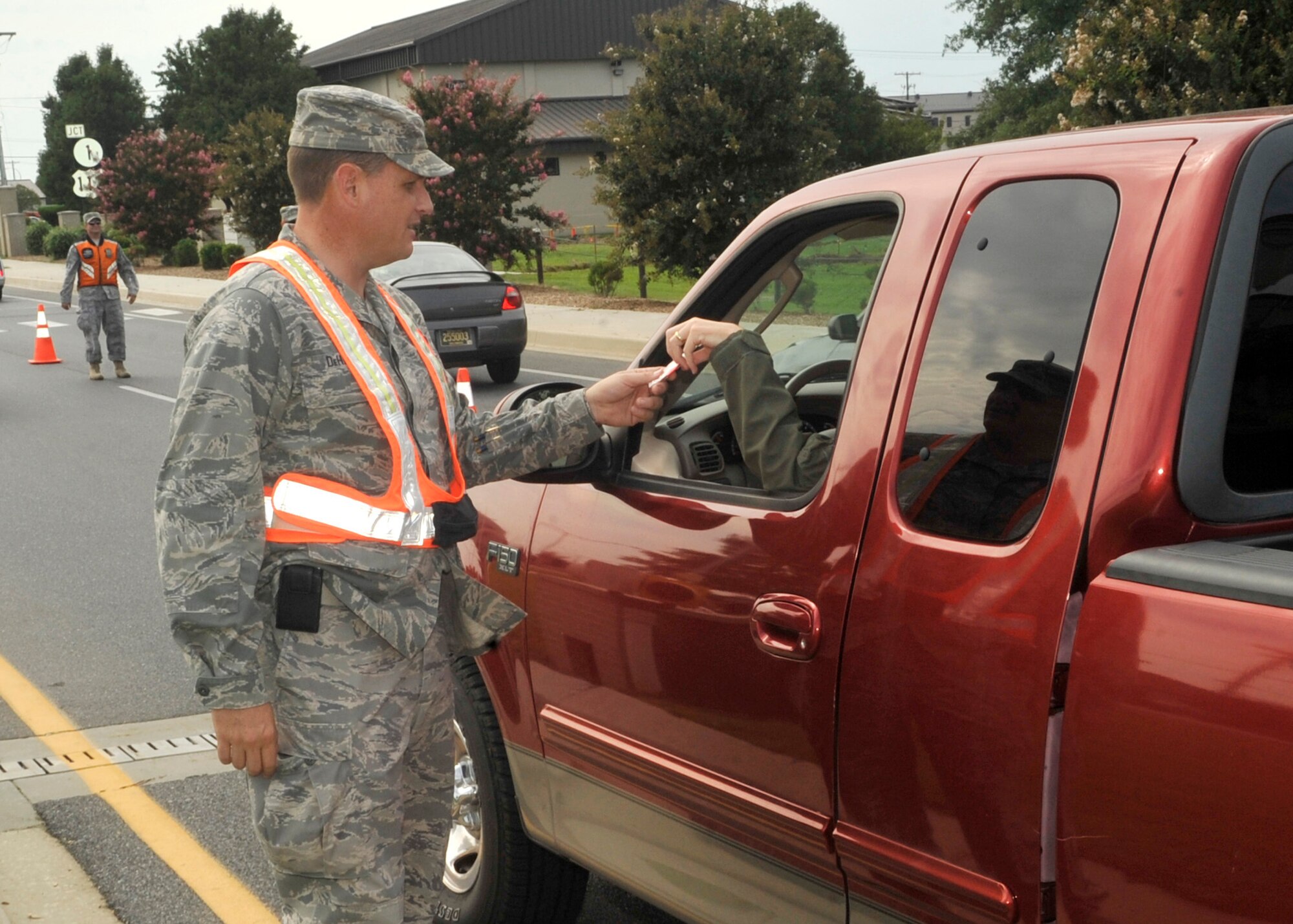 Lt. Col. James DeHaan, 436th Airlift Wing chief of safety, hands out a stop sign-shaped designated driver key chain Sept. 1, 2011, at the Dover Air Force Base, Del., main gate exit. The wing safety office handed out key chains and pens as Team Dover members left for the four-day Labor Day weekend, reminding people to have a designated driver if they plan on drinking. (U.S. Air Force photo by Tech Sgt. Chuck Walker)
