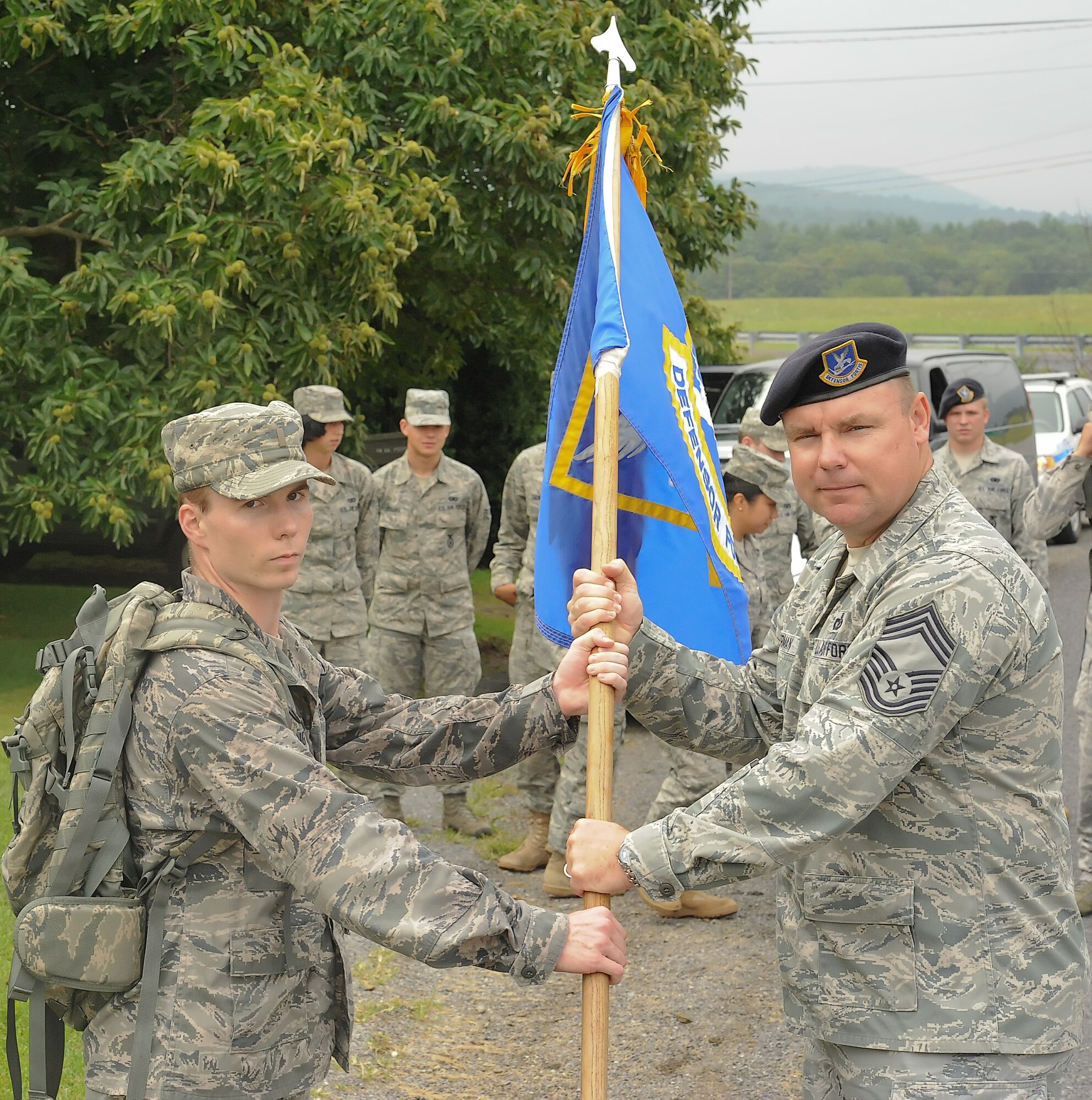 2nd Lt. Sean Long, 11th Security Forces Squadron, hands a security forces guide-on to Chief Master Sgt. Rich Sherman, 436th Security Forces Squadron, Sept. 1, 2011, in Wells Tannery, Pa. Wells Tannery was the beginning of Dover Air Force Base, Del.,’s part in the 9/11 Ruck March to Remember, which started in San Antonio and ends at Ground Zero in New York City on Sept. 11, 2011. (U.S. Air Force photo by Airman 1st Class Jacob Morgan)