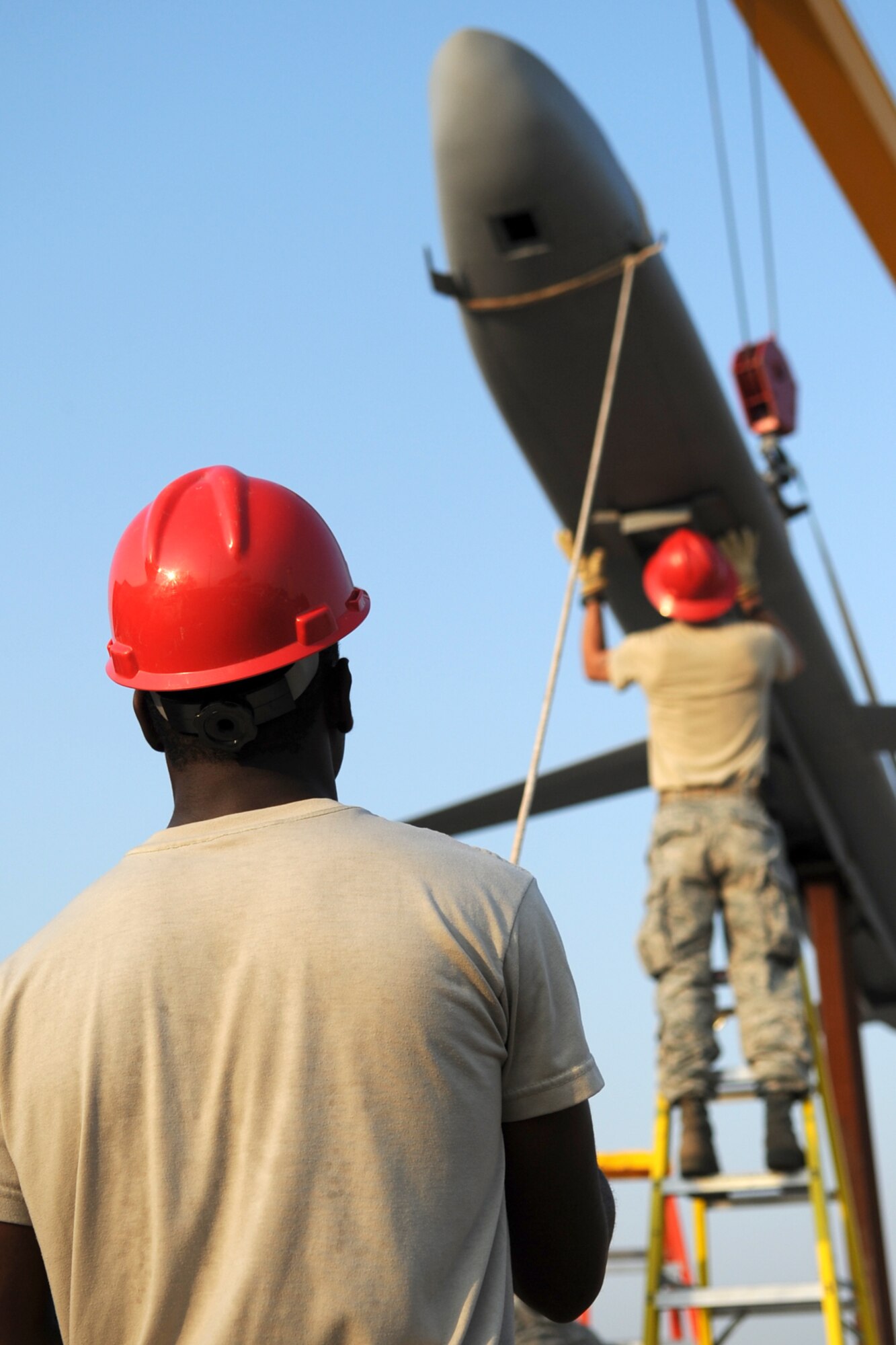 U.S. Air Force Senior Airman Cshamad Reed, a 307th Rapid Engineer Deployable Heavy Operational Repair Squadron Engineers specialist, (RED HORSE) mans a guide rope during the mounting a Conventional Air Launched Cruise Missile (CALCM) replica onto its pedestal at Barksdale Air Force Base, La., Aug. 31, 2011. The CALCM is the center piece of a monument dedicated to the weapon system and is scheduled to be unveiled on Sept. 9, 2011. (U.S. Air Force photo by Master Sgt. Greg Steele/Released)