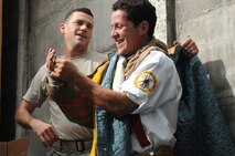 Tech. Sgt. Nicholas Sebastiani, a bioenvironmental engineer with the 916th Aerospace Medicine Squadron and a firefighter in his civilian capacity, shows a member of the volunteer fire department here how to properly don the equipment provided by Sebastiani's employer, GlaxoSmithKline. The company, which has its own fire department, donated used suits, boots, gloves and helmets to their Nicaraguan sounterparts here Aug. 8, 2011 .  (USAF photo by Senior Airman Meredith A. H. Thomas, 916 ARW/PA)

