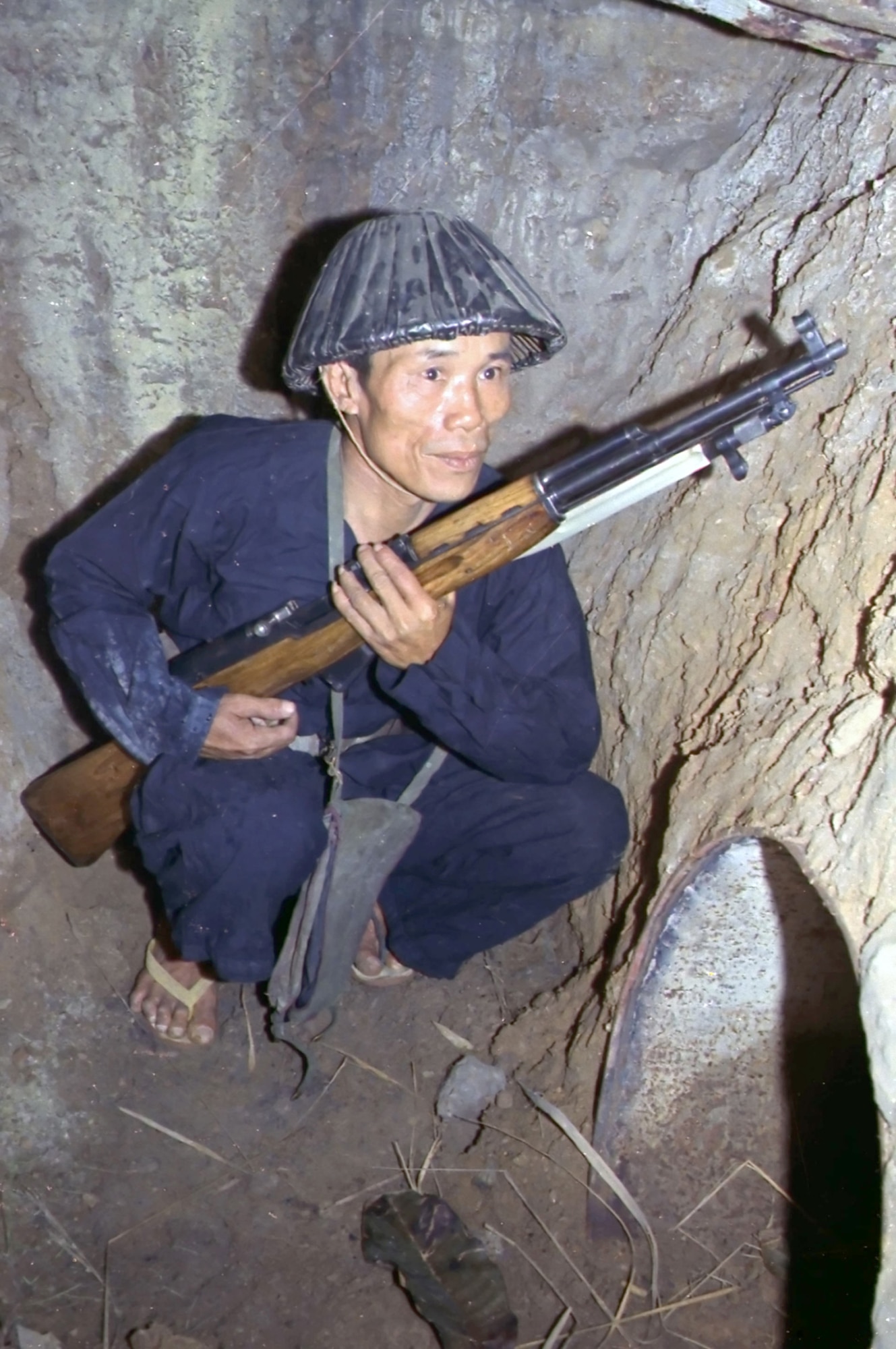 Viet Cong insurgent crouching in a bunker holding an SKS rifle. (U.S. Air Force photo).
