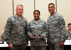 Senior Airman Showanna Ferguson receives the Diamond Sharp award from Col. Erik Hansen and Chief Master Sgt. Terrence Greene at Joint Base Charleston Sept. 6. Diamond Sharp awardees are Airmen chosen by their first sergeants for their excellent performance. Hansen is the 437th Airlift Wing commander, Greene is the 437 AW command chief and Ferguson is assigned to the 437th Maintenance Operations Squadron. Other Diamond Sharp winners not pictured include Airmen 1st Class Bianca Flores, 437th Aircraft Maintenance Squadron, Daniel Jones, 437th Maintenance Squadron and Daniel Godfrey, 437th Operations Support Squadron. (U.S. Air Force photo/Staff Sgt. Katie Gieratz)

