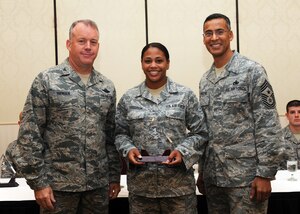 Senior Airman Shwanna Ferguson receives the Diamond Sharp award from Col. Erik Hansen and Chief Master Sgt. Terrence Greene at Joint Base Charleston Sept. 6. Diamond Sharp awardees are Airmen chosen by their first sergeants for their excellent performance. Hansen is the 437th Airlift Wing commander, Greene is the 437 AW command chief and Ferguson is assigned to the 437th Maintenance Operations Squadron. Other Diamond Sharp winners not pictured include Airmen 1st Class Bianca Flores, 437th Aircraft Maintenance Squadron, Daniel Jones, 437th Maintenance Squadron and Daniel Godfrey, 437th Operations Support Squadron. (U.S. Air Force photo/Staff Sgt. Katie Gieratz)(RELEASED)