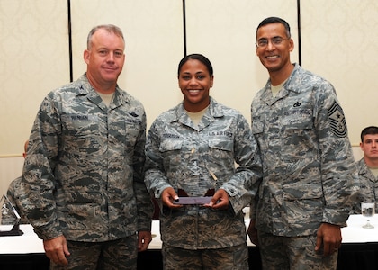 Senior Airman Shwanna Ferguson receives the Diamond Sharp award from Col. Erik Hansen and Chief Master Sgt. Terrence Greene at Joint Base Charleston Sept. 6. Diamond Sharp awardees are Airmen chosen by their first sergeants for their excellent performance. Hansen is the 437th Airlift Wing commander, Greene is the 437 AW command chief and Ferguson is assigned to the 437th Maintenance Operations Squadron. Other Diamond Sharp winners not pictured include Airmen 1st Class Bianca Flores, 437th Aircraft Maintenance Squadron, Daniel Jones, 437th Maintenance Squadron and Daniel Godfrey, 437th Operations Support Squadron. (U.S. Air Force photo/Staff Sgt. Katie Gieratz)(RELEASED)