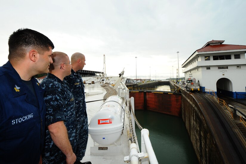 (From left) Hospital Corpsman 1st Class Joseph Stocking, from Rochester, Ind., Lt. j.g. Robert Bailey, from Salt Lake City and Lt. j.g. Anthony Capuano, from Los Angeles, watch as USNS Comfort (T-AH 20) approaches the first lock during her transit through the Panama Canal. (U.S. Air Force photo by Senior Airman Kasey Close/RELEASED)