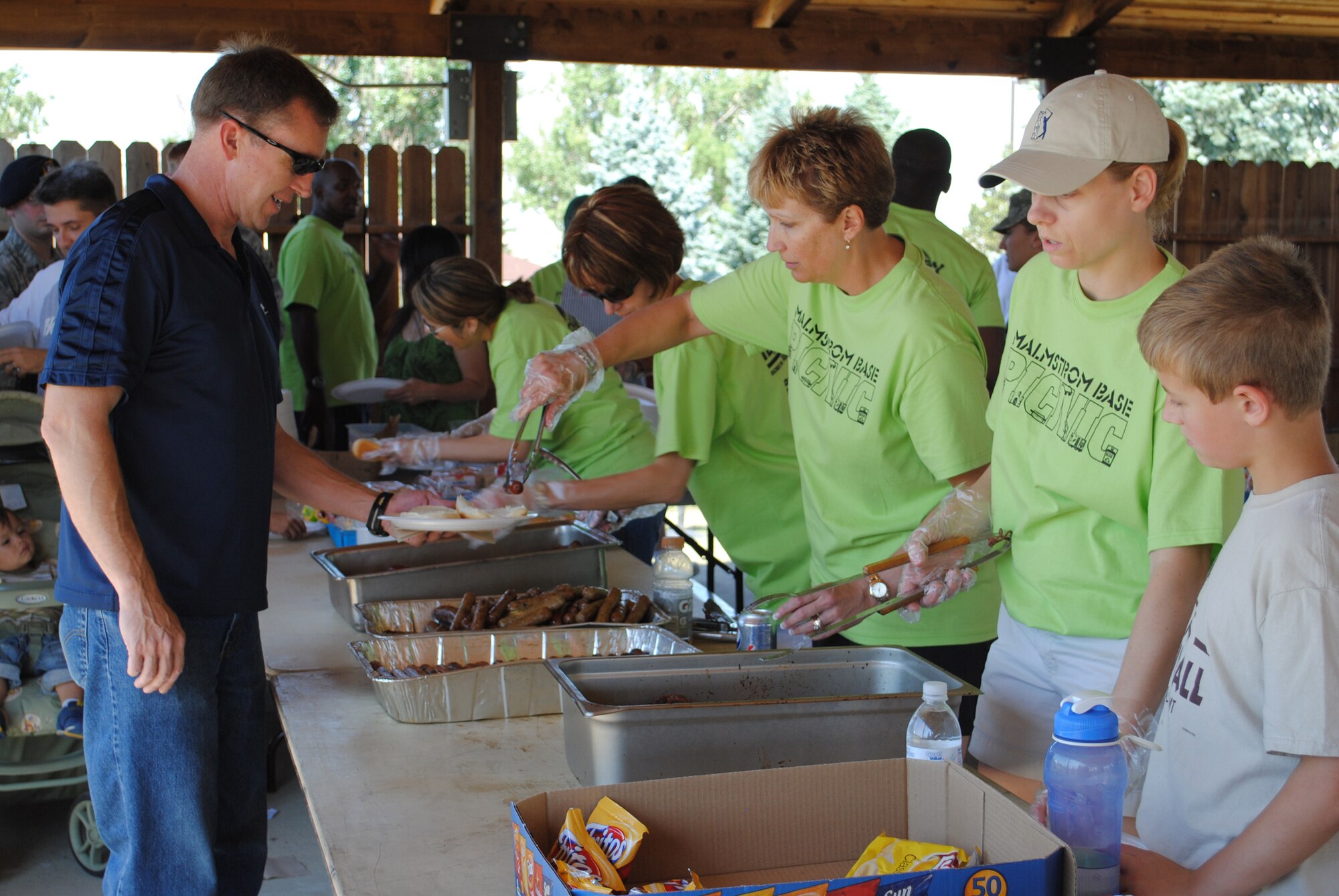 Volunteers from Malmstrom and Great Falls serve food to those attending the base picnic. Great Falls' Military Affairs Committee, along with other community groups, put on this successful event for the fourth time. (U.S. Air Force photo/Cortney Paxton)
